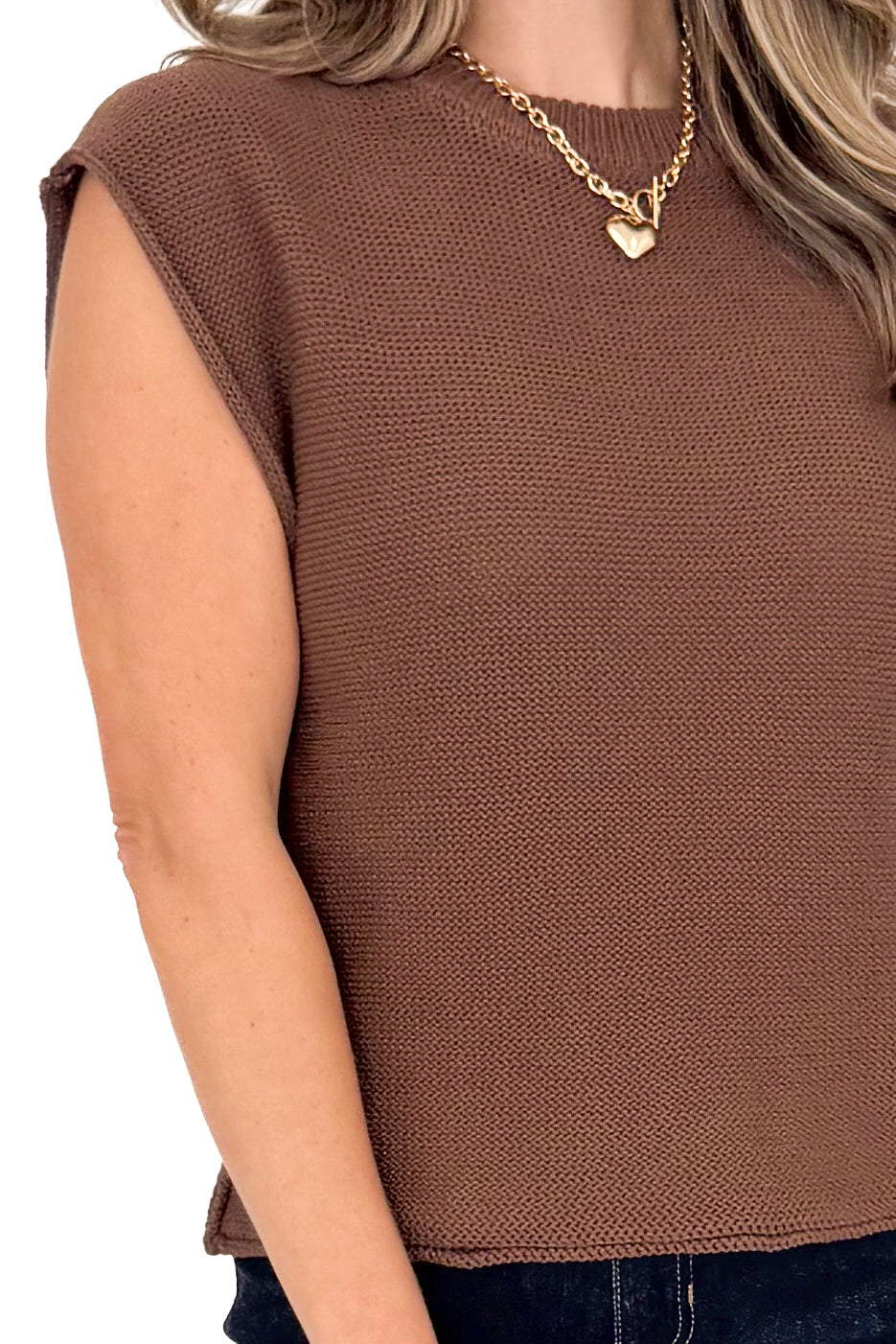 Detailed front view of woman wearing brown sweater against white studio background.