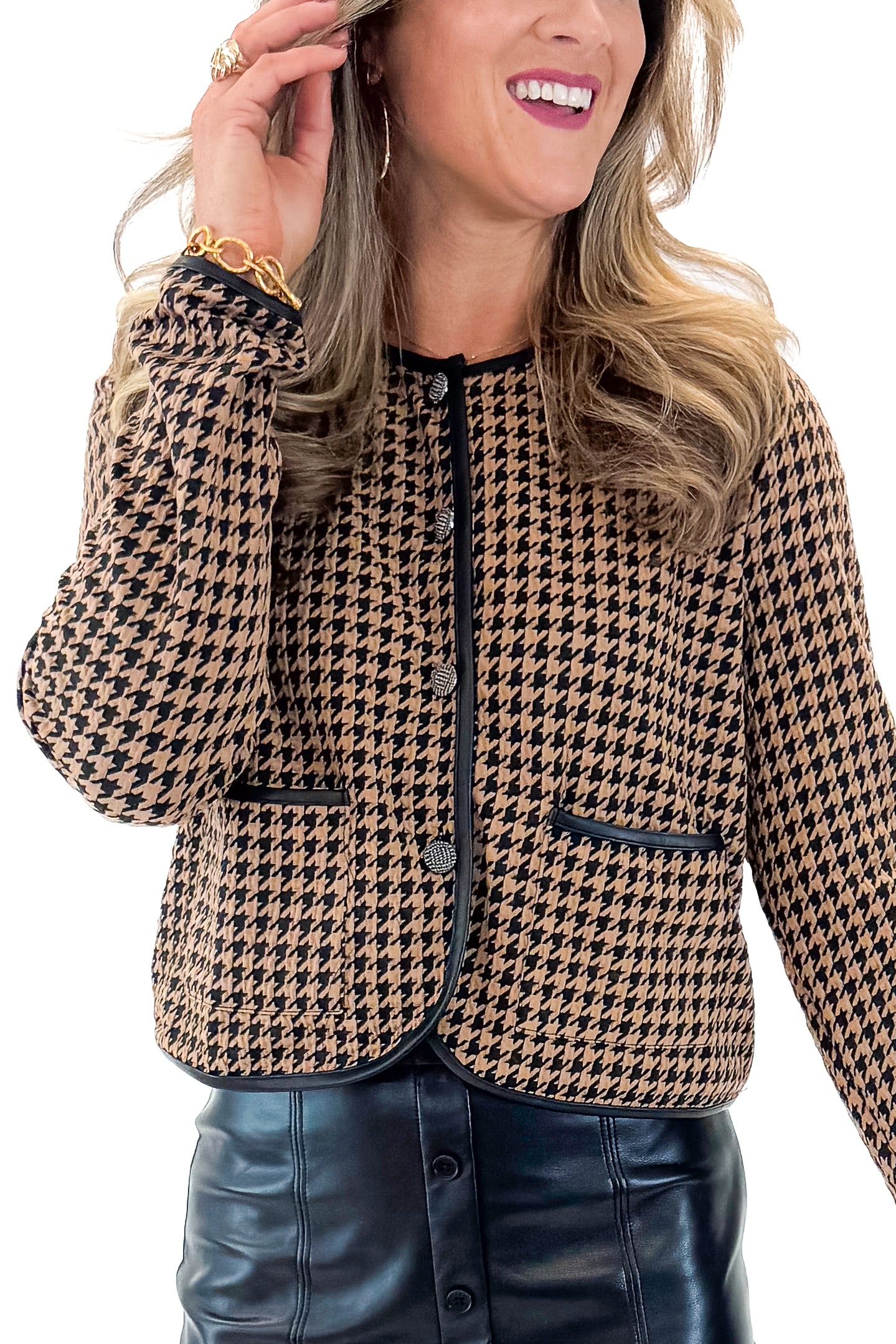 Front detail view of woman wearing Black & Brown Houndstooth Jacket with black faux leather skirt against white studio background.