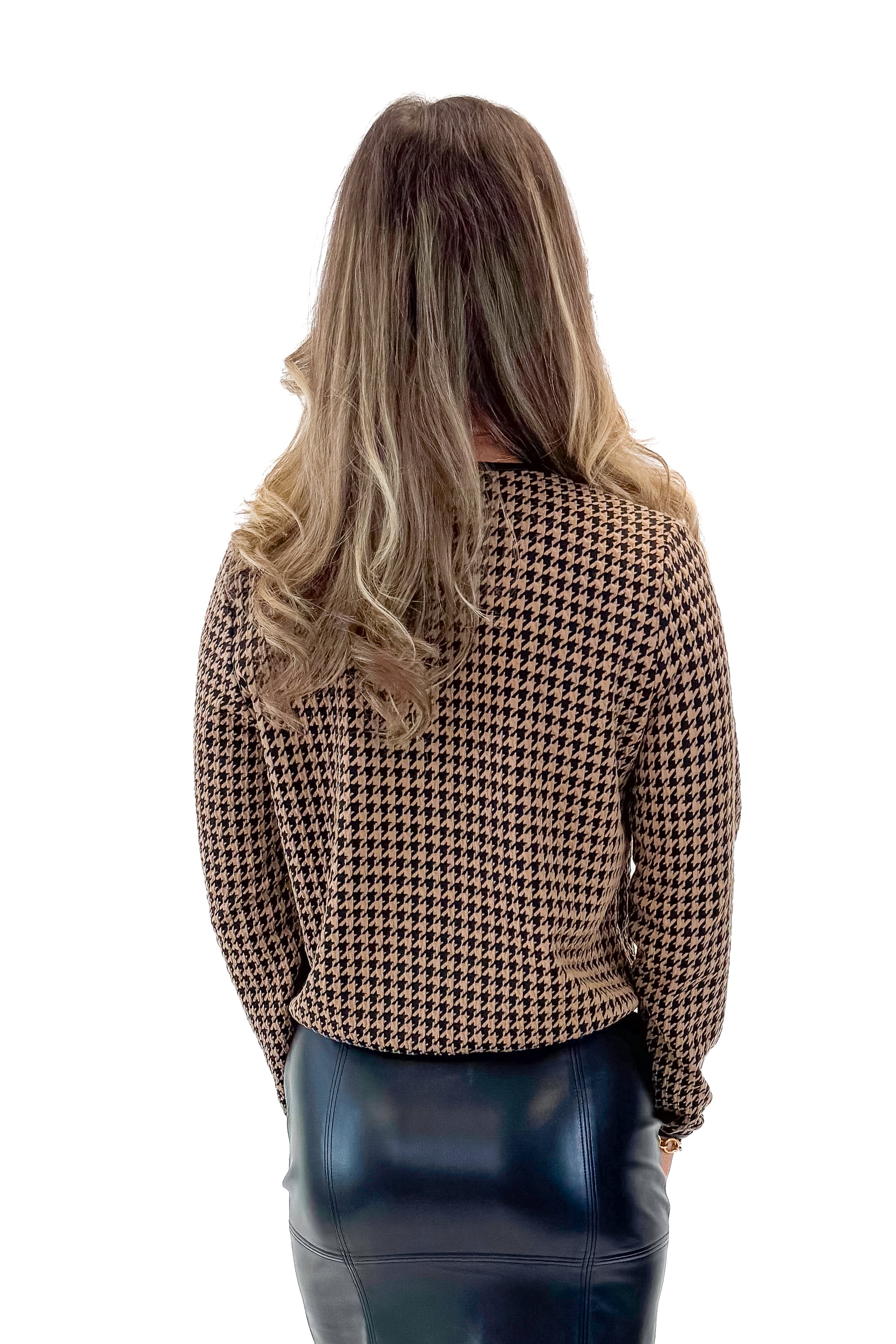 Back view of woman wearing Black & Brown Houndstooth Jacket with black faux leather skirt against white studio background.