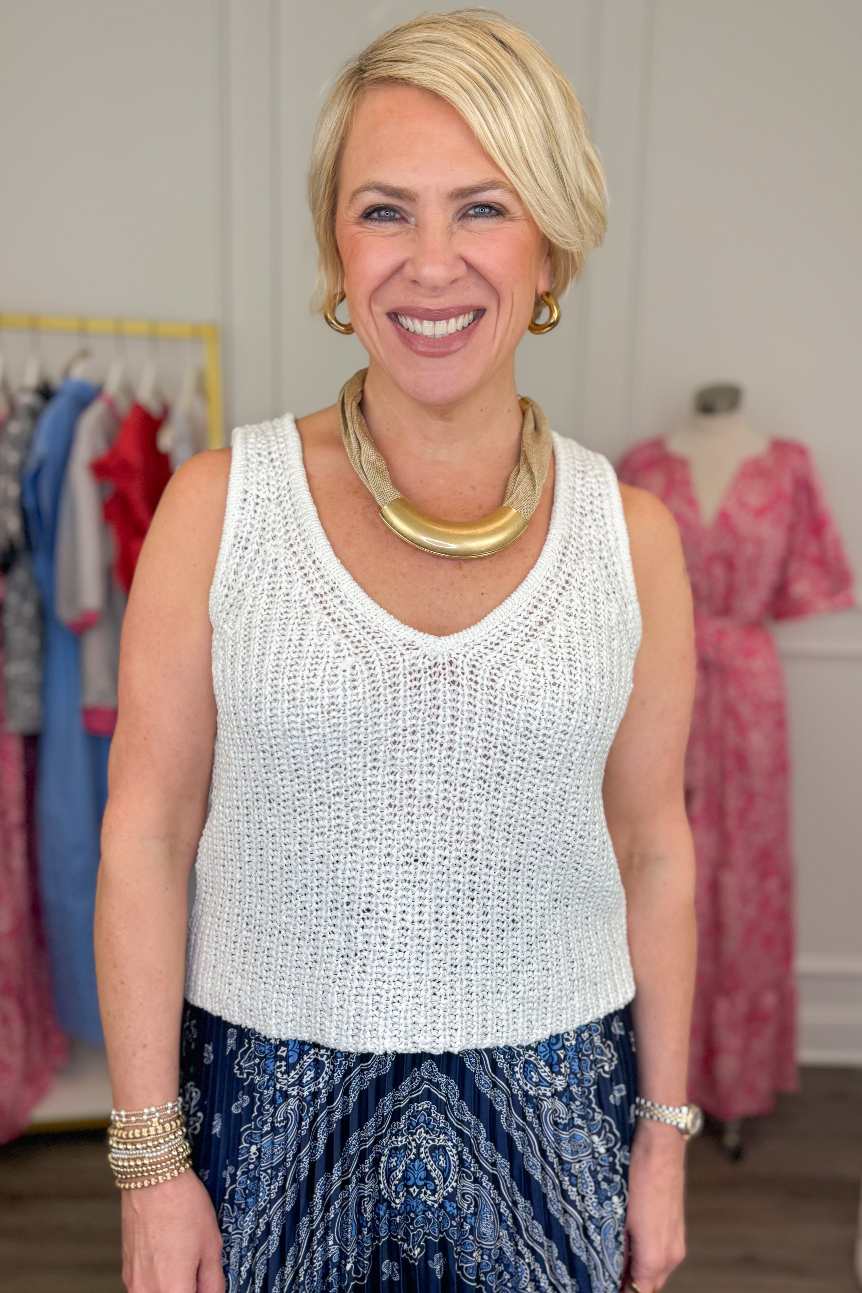 Front view of woman wearing White V-Neck Knitted Tank by Skies Are Blue with skirt.