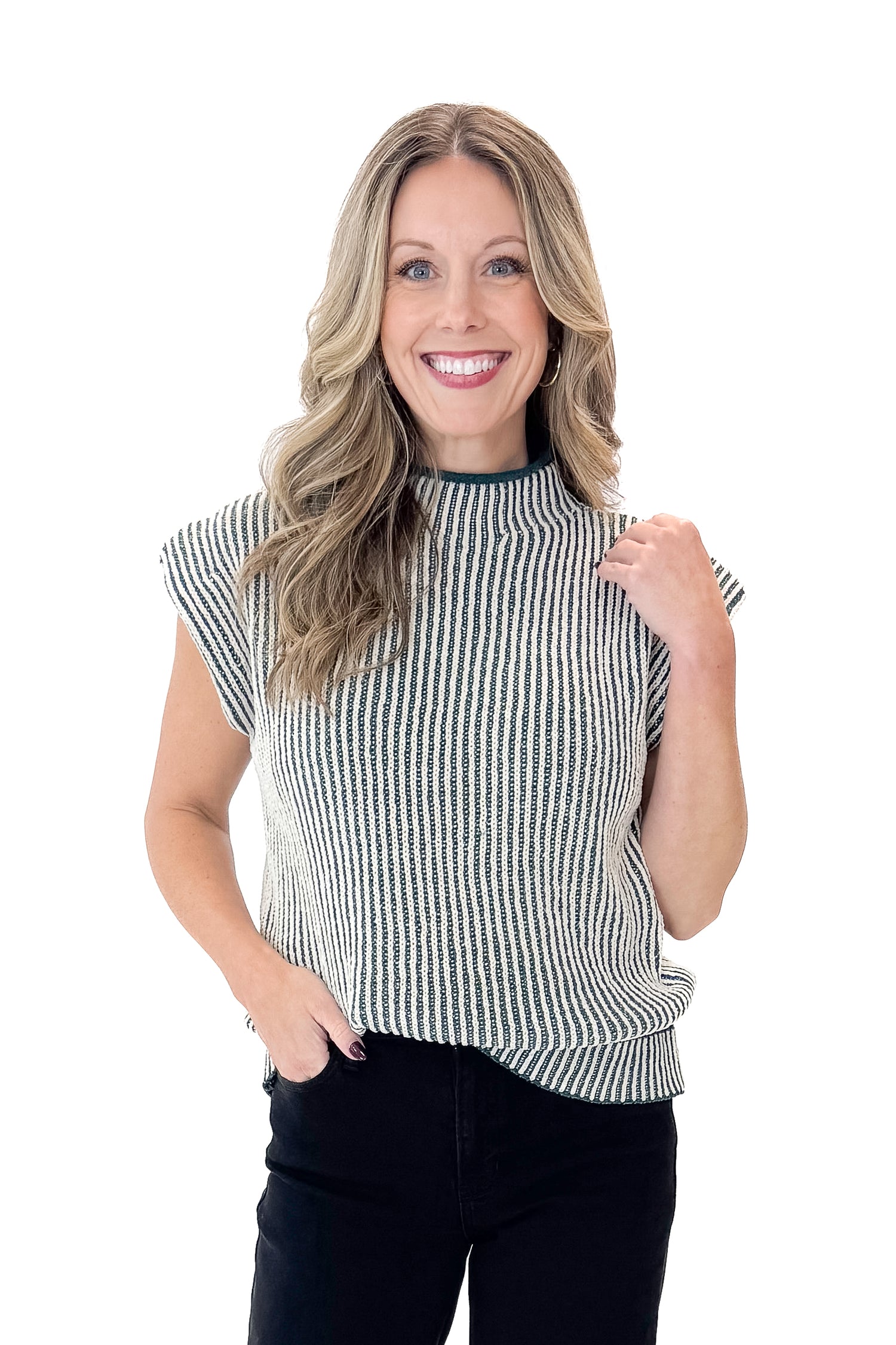 Front view of woman wearing sweater with jeans against white studio background.