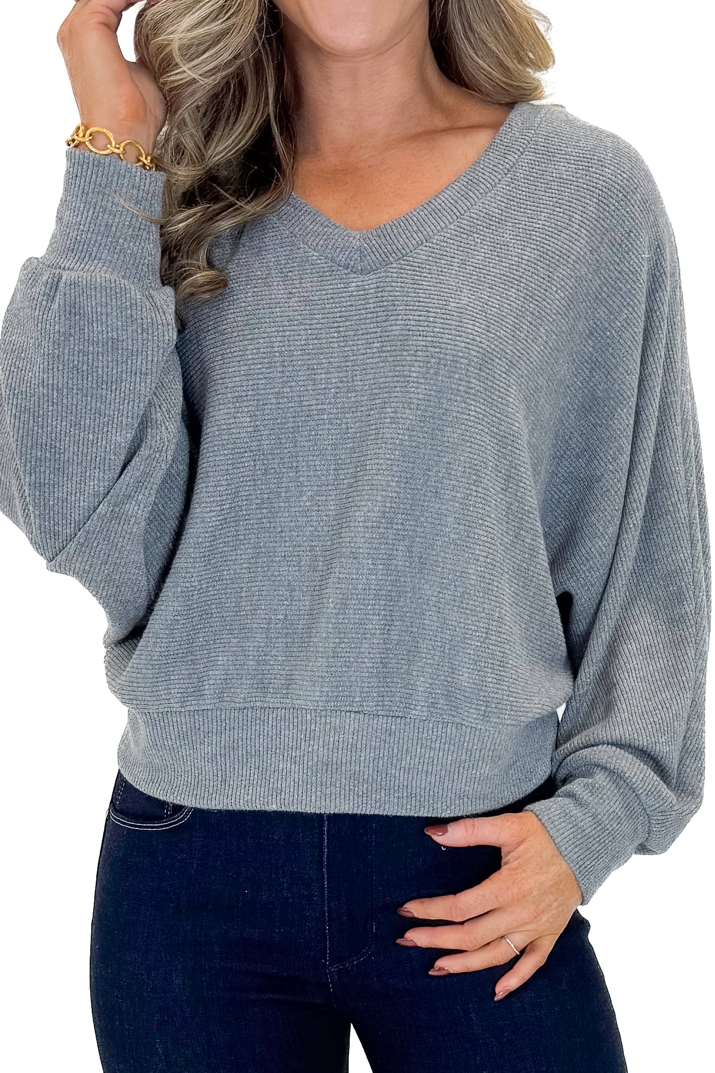 Front detail view of woman wearing Heather Grey Ribbed V-neck Banded Top with jeans against white studio background.