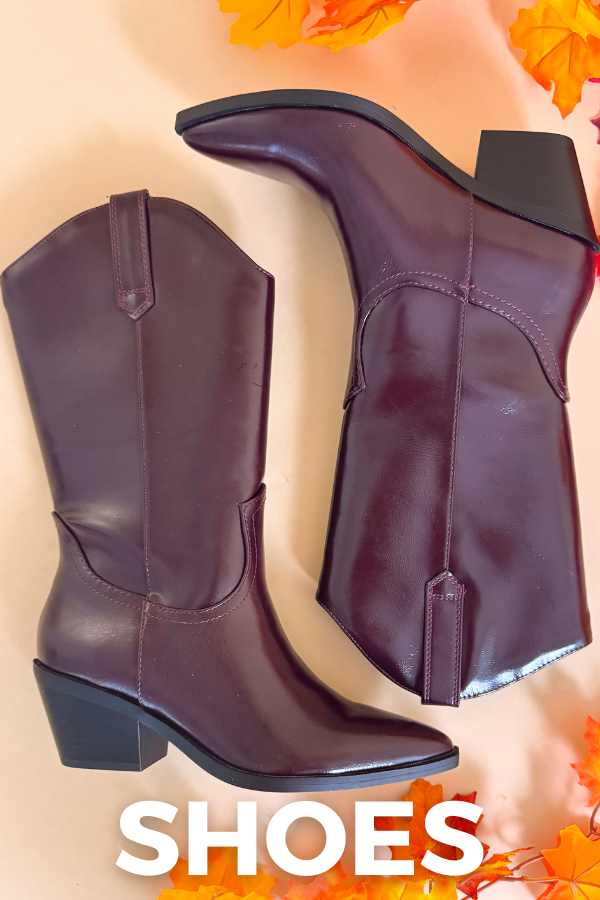 Pair of purple cowboy boots on a beige background with autumn leaves.