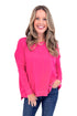 Woman wearing a pink long-sleeve top and blue jeans on a white background