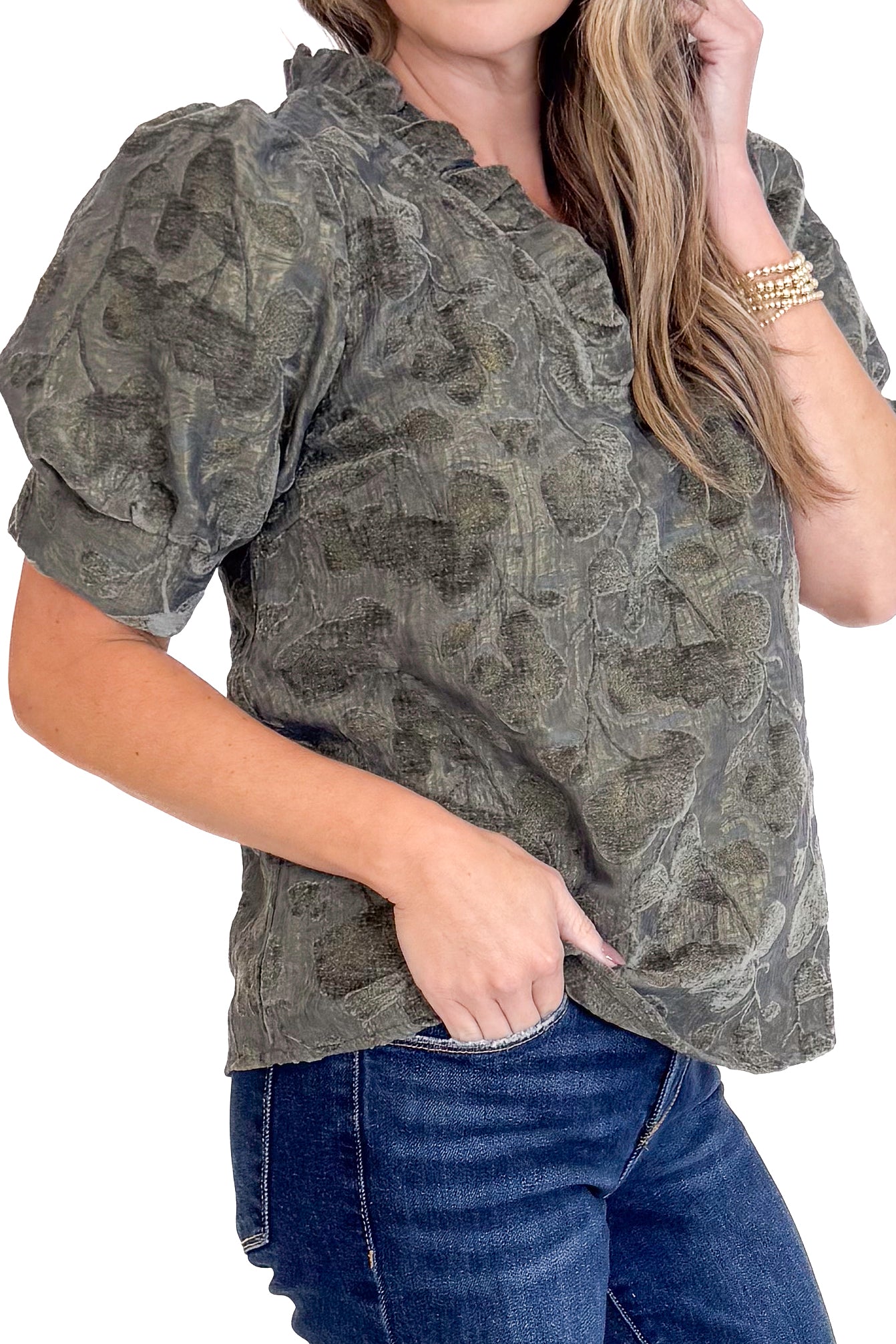 Woman wearing a patterned blouse and jeans on a white background