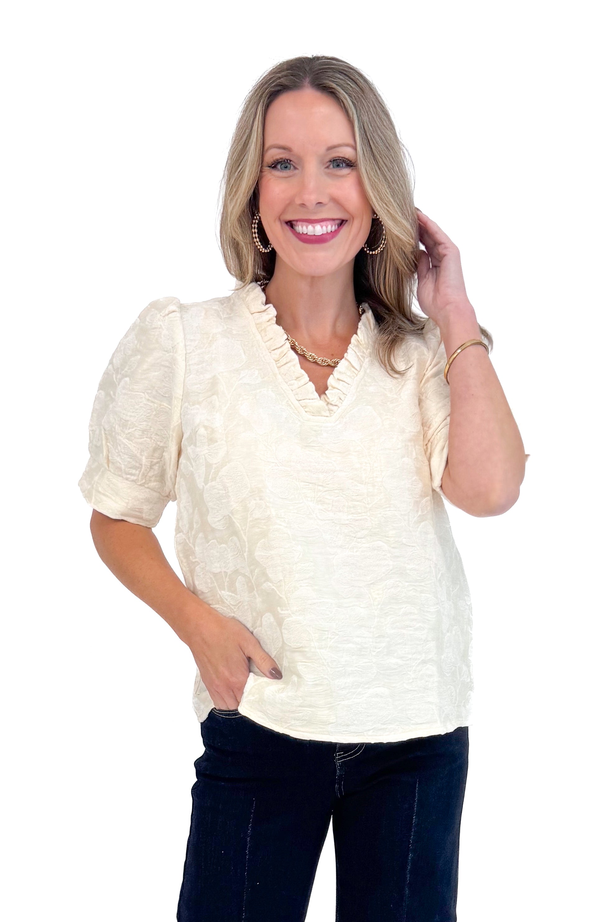 Front view of woman wearing Cream Floral Textured V-neck Top and blue jeans.