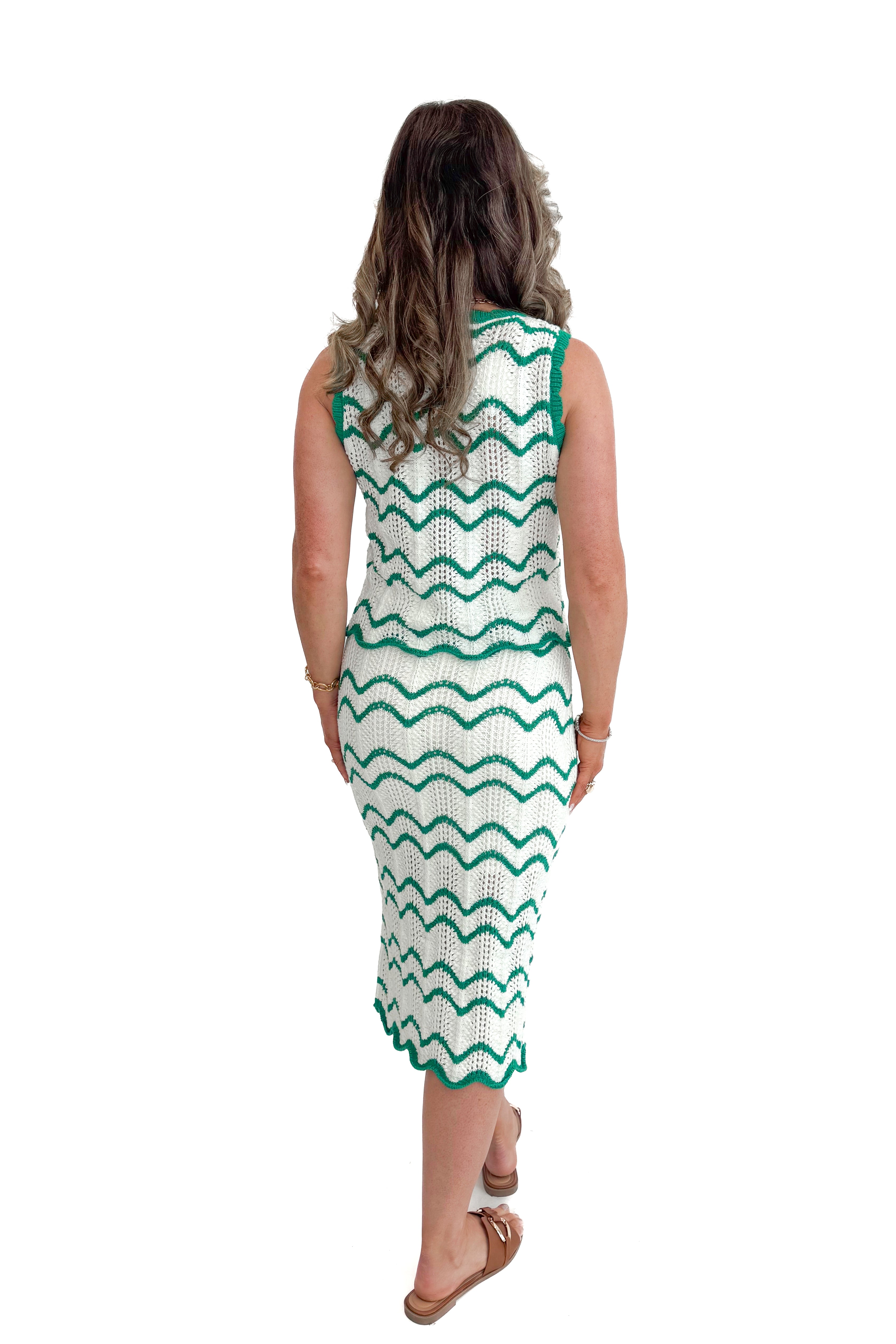 Back view of woman wearing Ivory & Green Scalloped Tank by Skies Are Blue with matching skirt against white studio background.