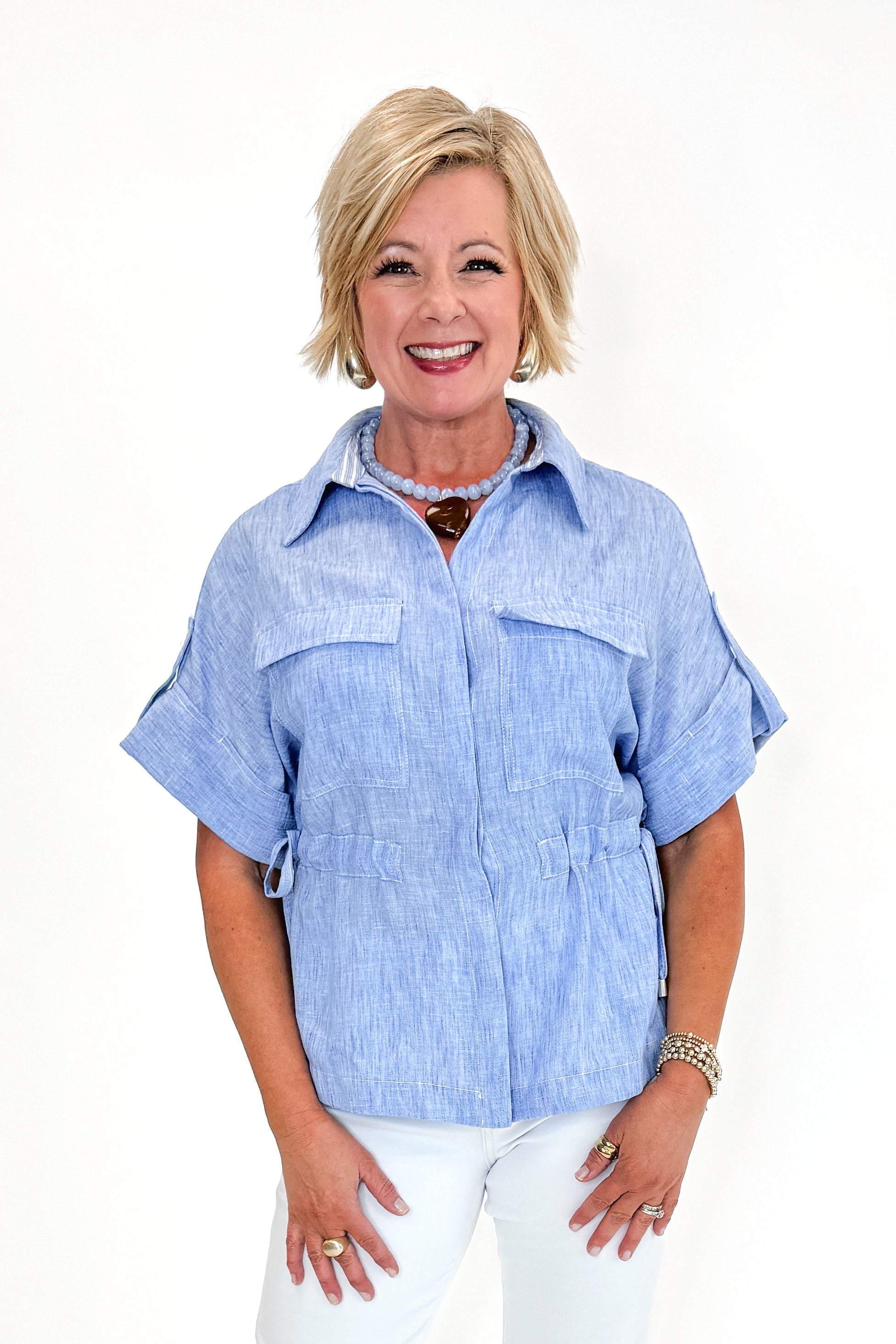 Front view of woman wearing Chambray Cinched Waist Top by Skies Are Blue against white studio background.