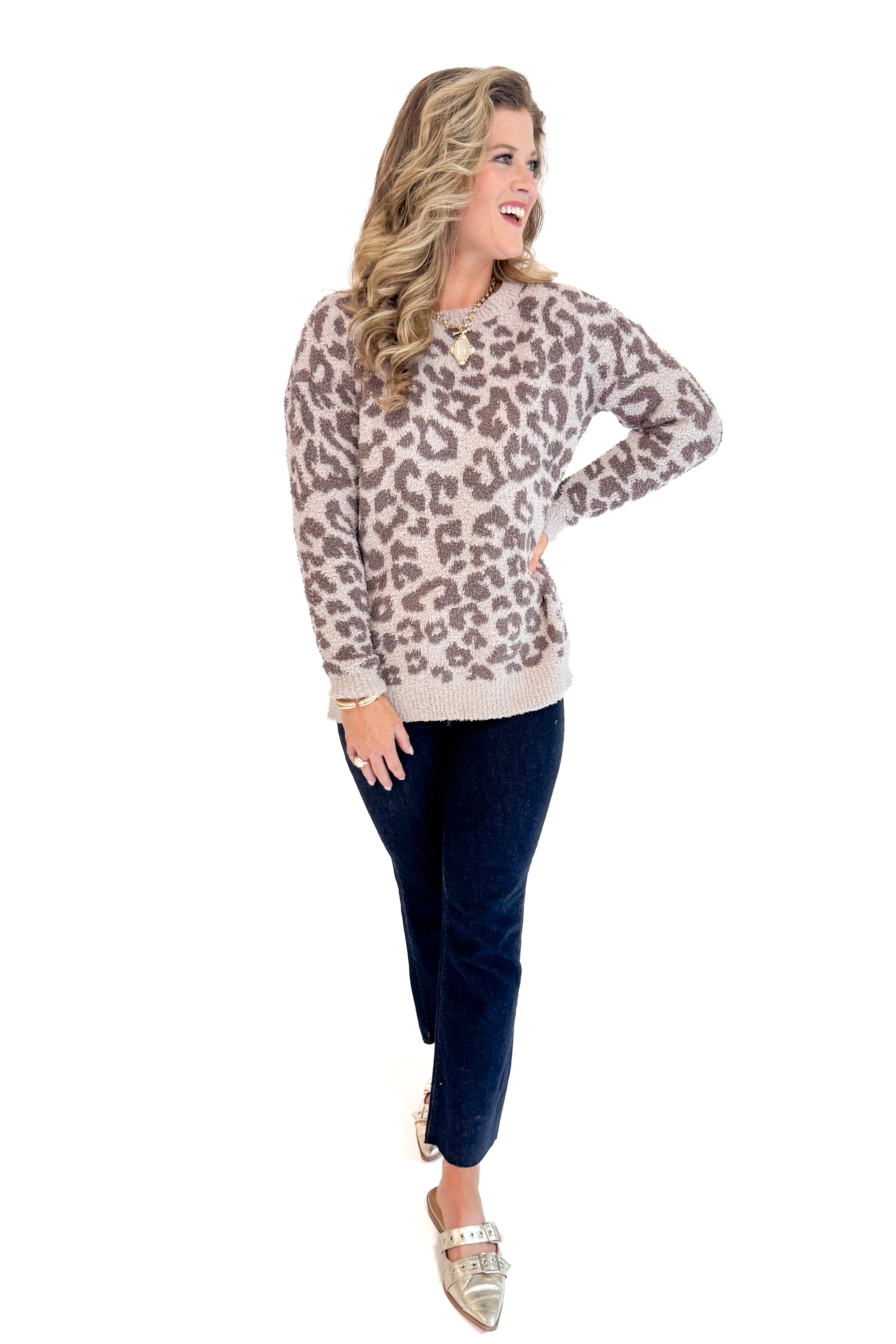 Woman wearing Mocha Leopard Fuzzy Sweater and jeans with white background.