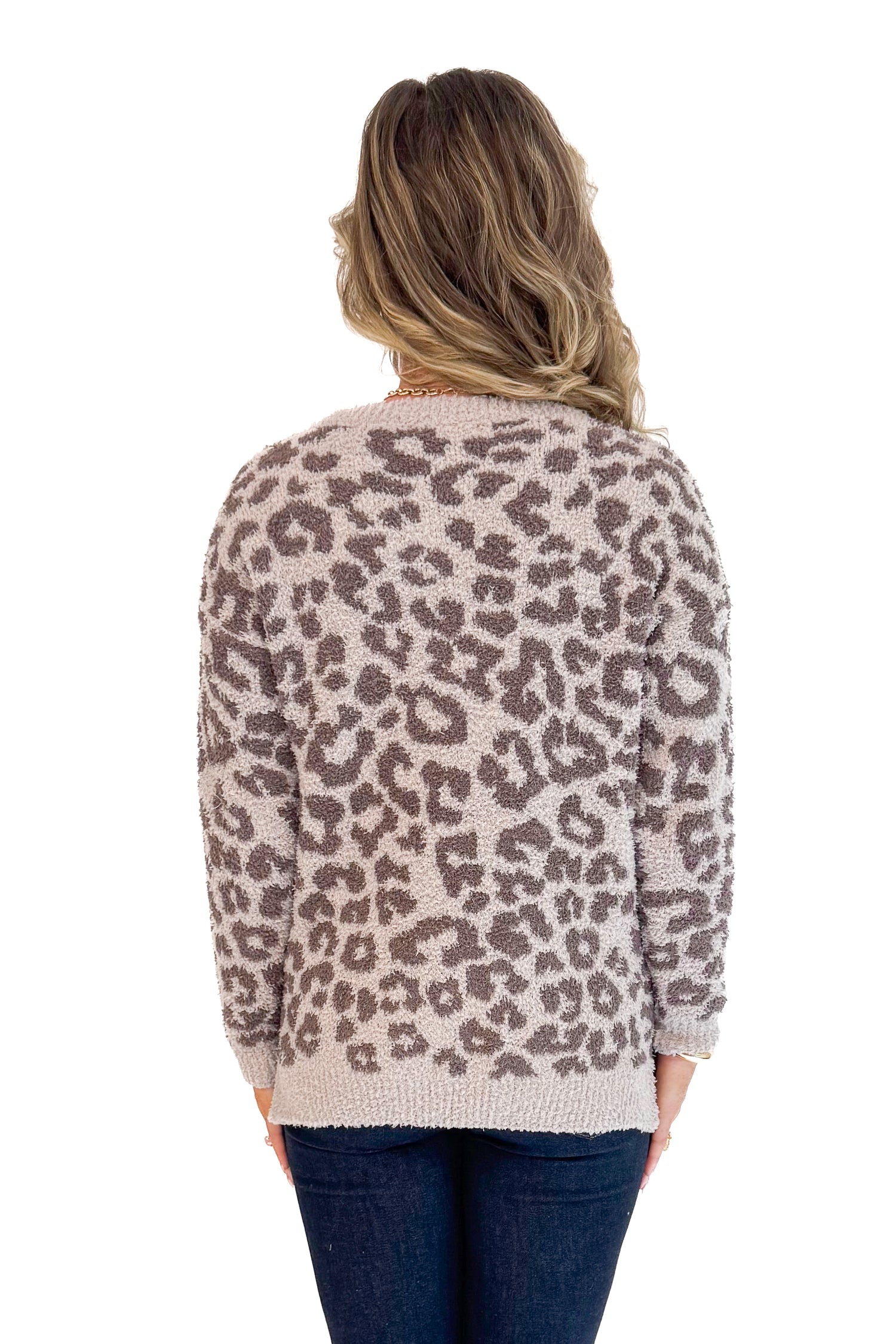 Back view of woman wearing Mocha Leopard Fuzzy Sweater and jeans with white background.