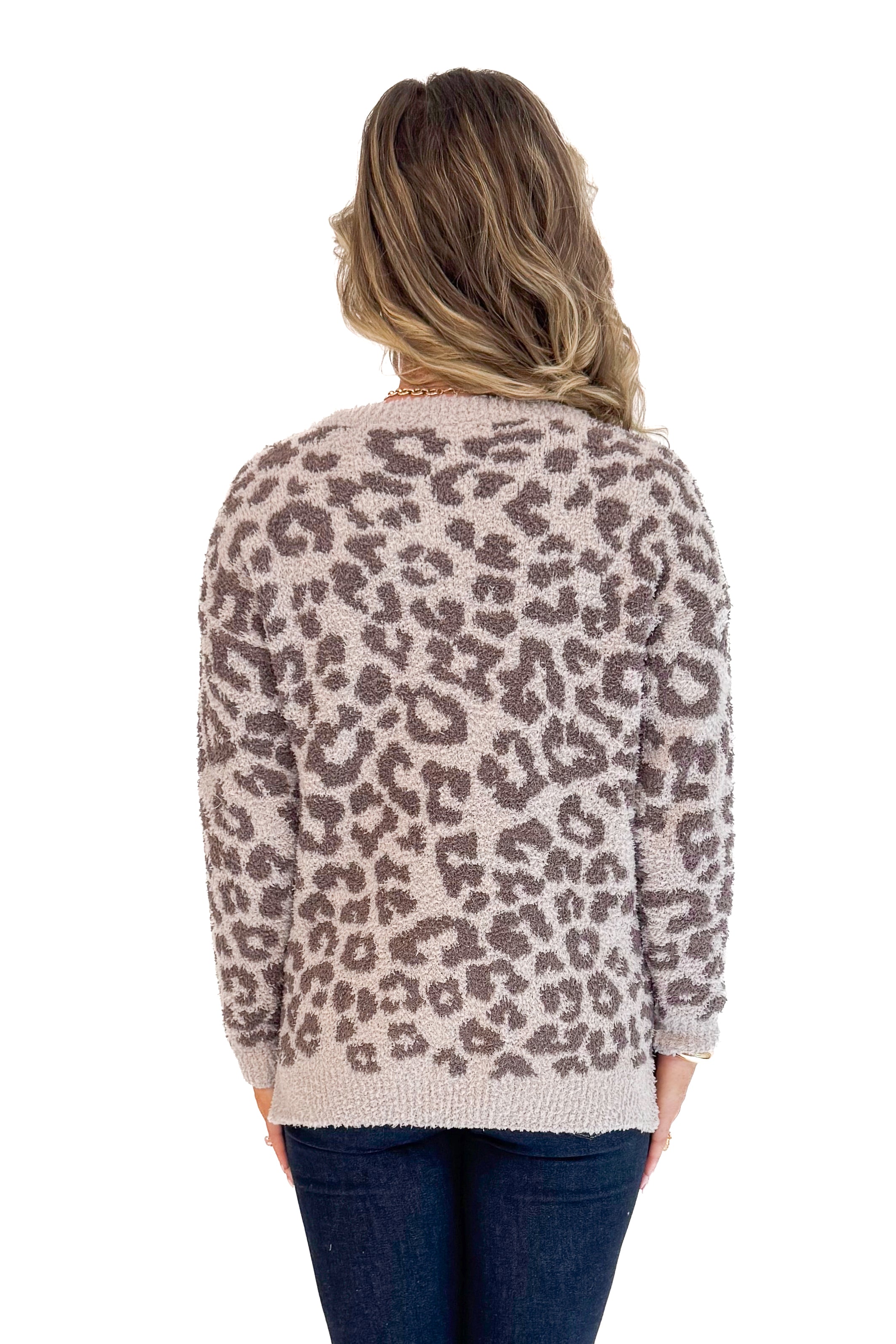 Back view of woman wearing Mocha Leopard Fuzzy Sweater and jeans with white background.