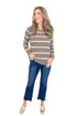 Front view of woman wearing striped sweater with jeans against white studio background.