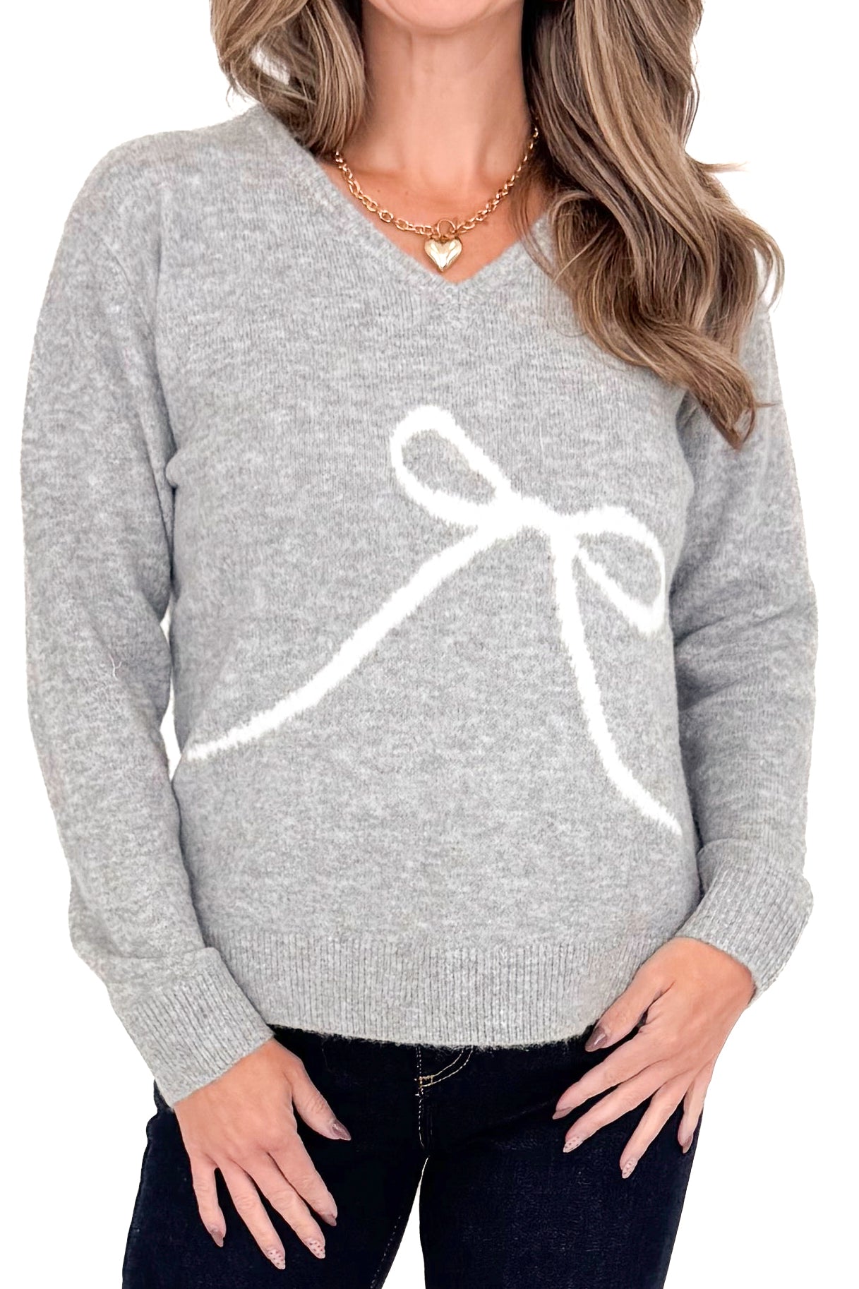 Front detailed view of woman wearing Grey Bow Printed Sweater with jeans against white studio background.