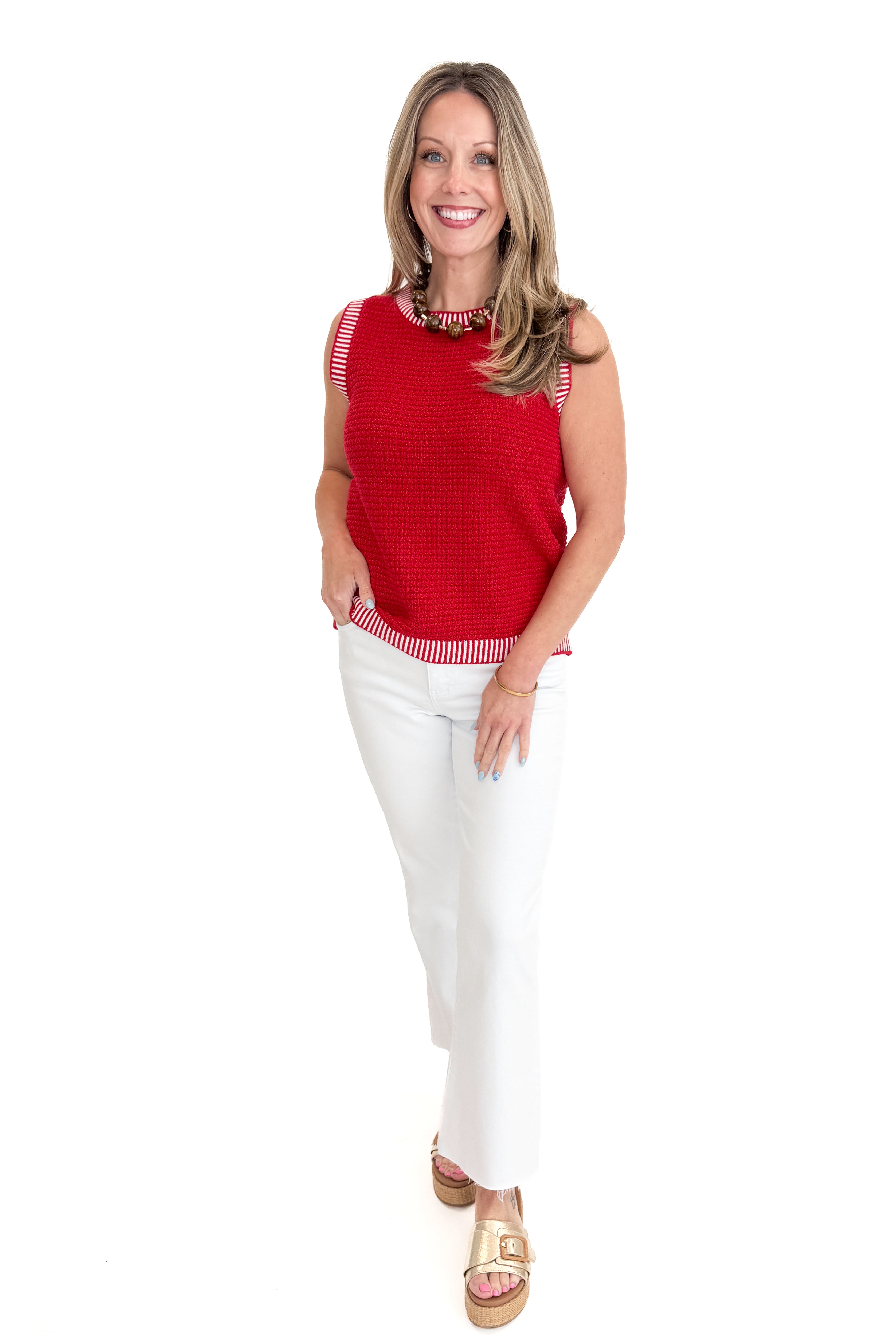 Front view of woman wearing Red & White Textured Sweater Tank with jeans against white studio background.