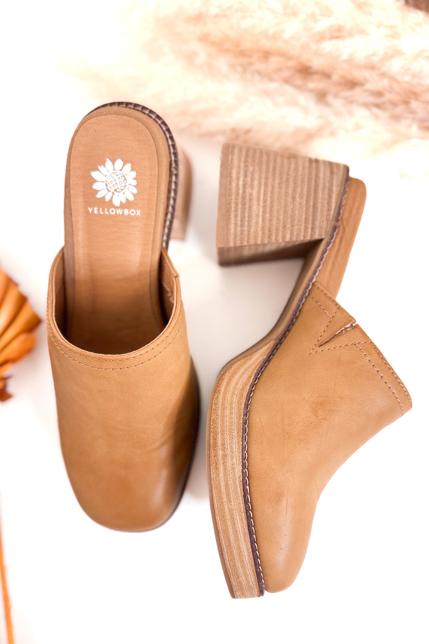 Tan clogs with a visible brand logo on a light background