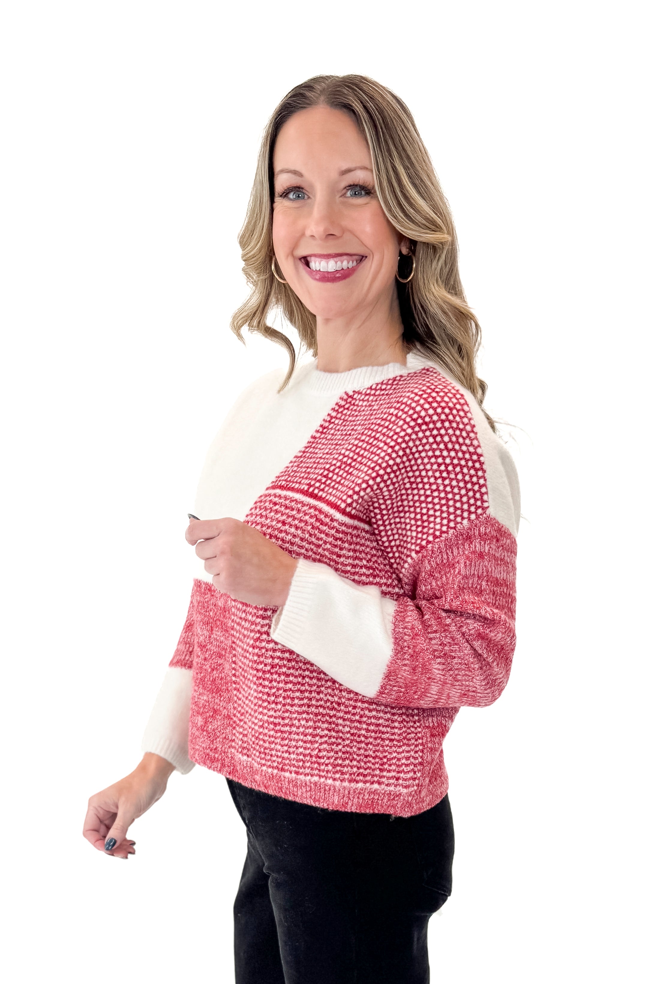 Side view of woman wearing Cream & Red Color Block Sweater with jeans against white studio background.
