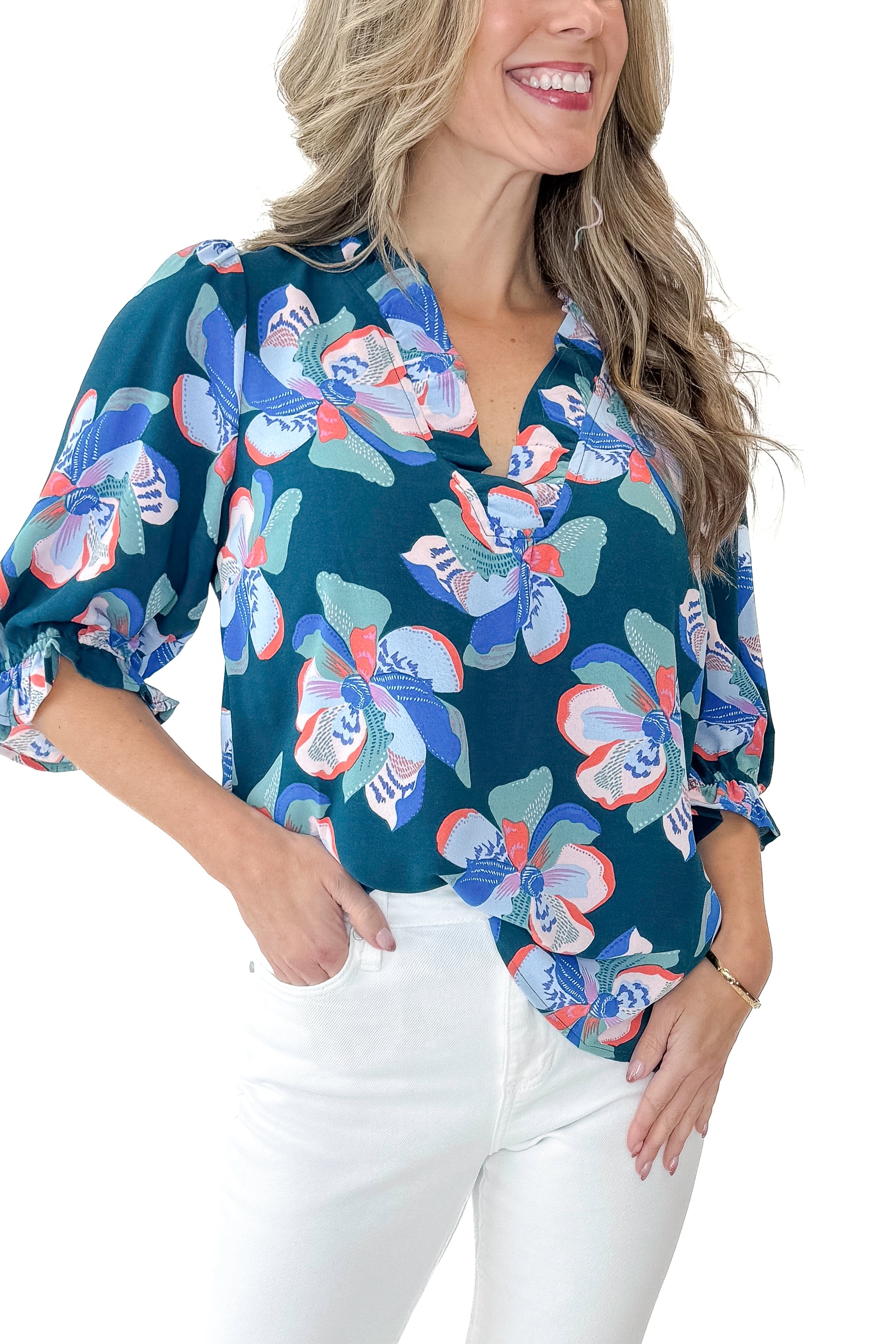 Front detail view of woman wearing Green & Pink Floral Julie Top with jeans against white studio background.