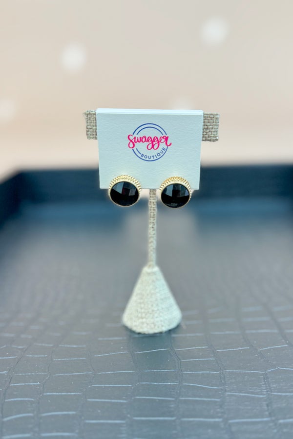 Black and gold earrings on a display card with &