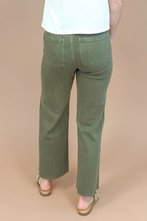 Person wearing green pants on a beige background