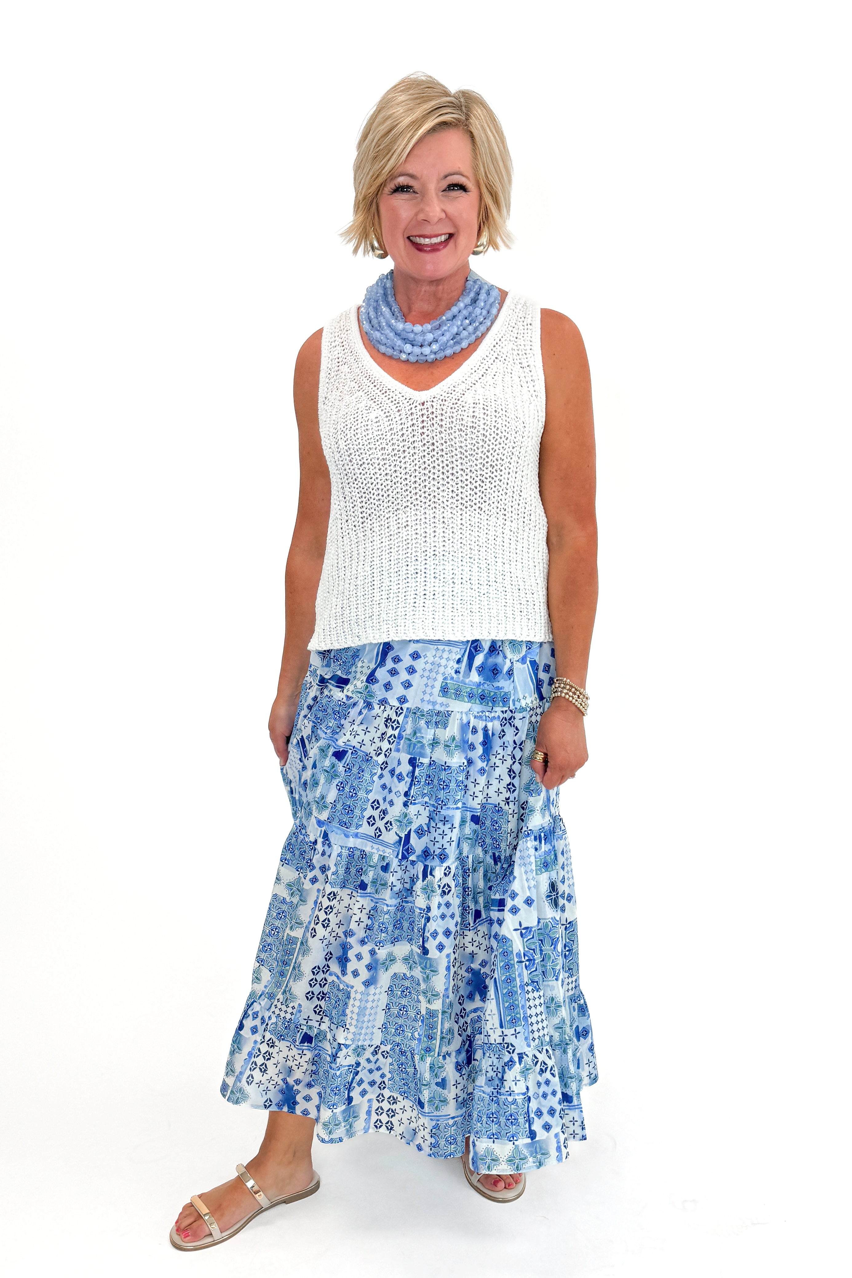 Front view of woman wearing top with Blue Patchwork Print Tiered Skirt by PINCH against white studio background.