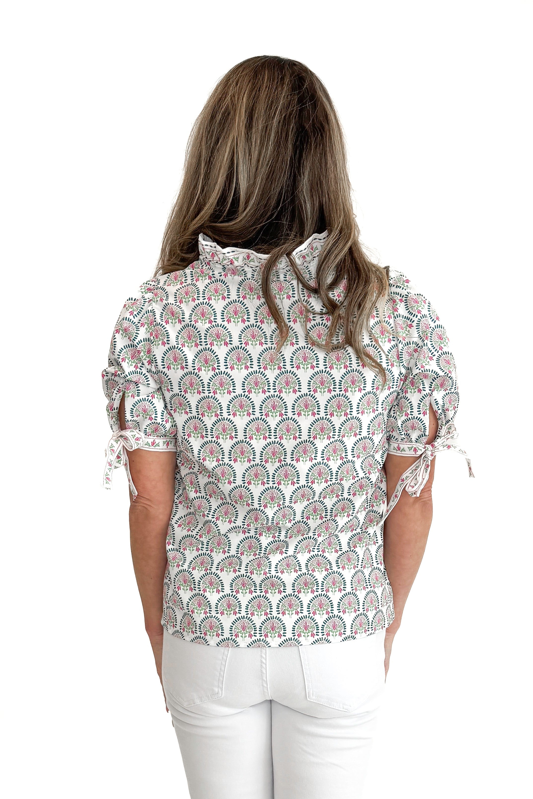 Back view of woman wearing White & Multi Sunshower Flora Brynn Top by Mary Square with jeans against white studio background.