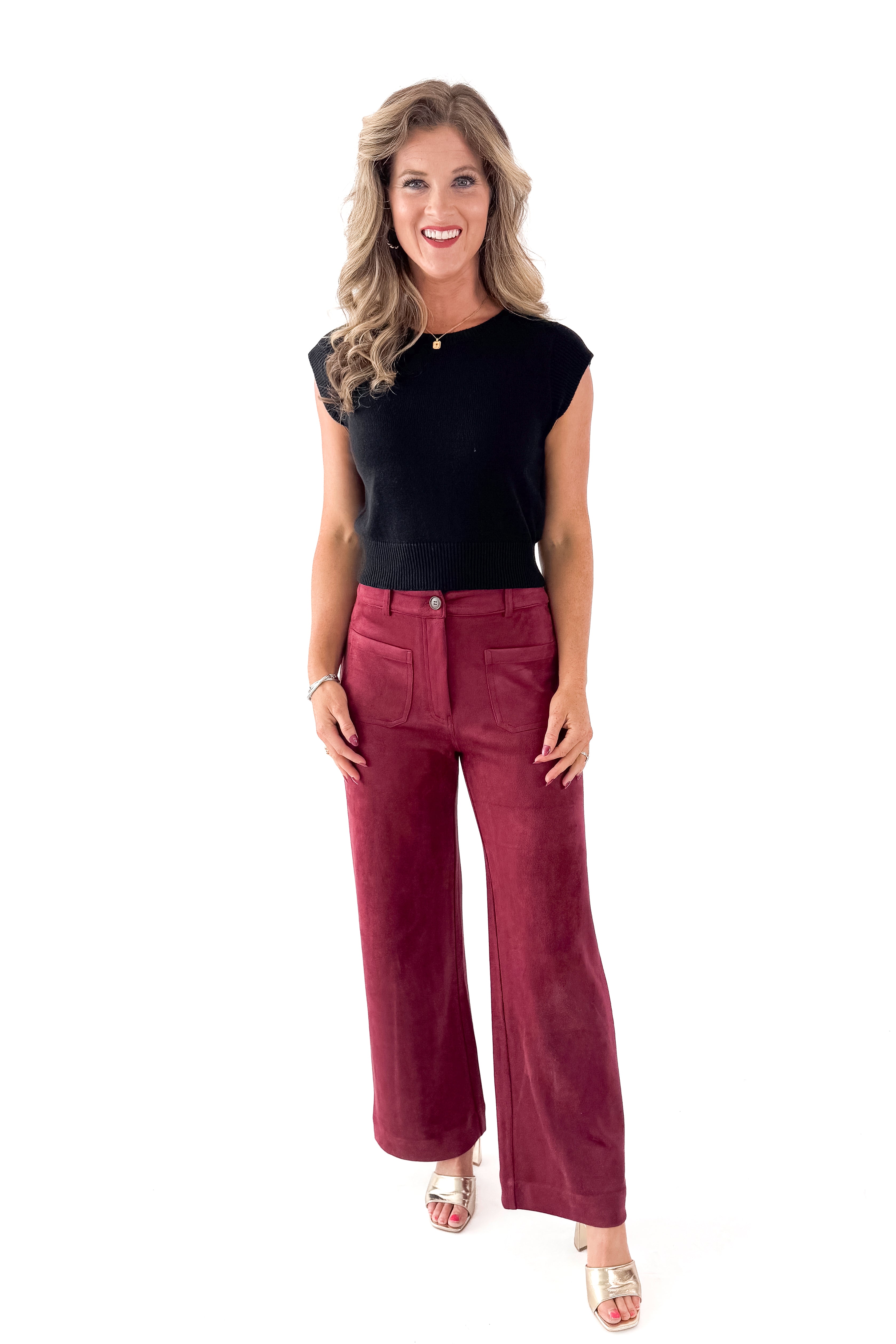 Front view of woman wearing sweater with Burgundy Suede Wide Leg Pants against white studio background.