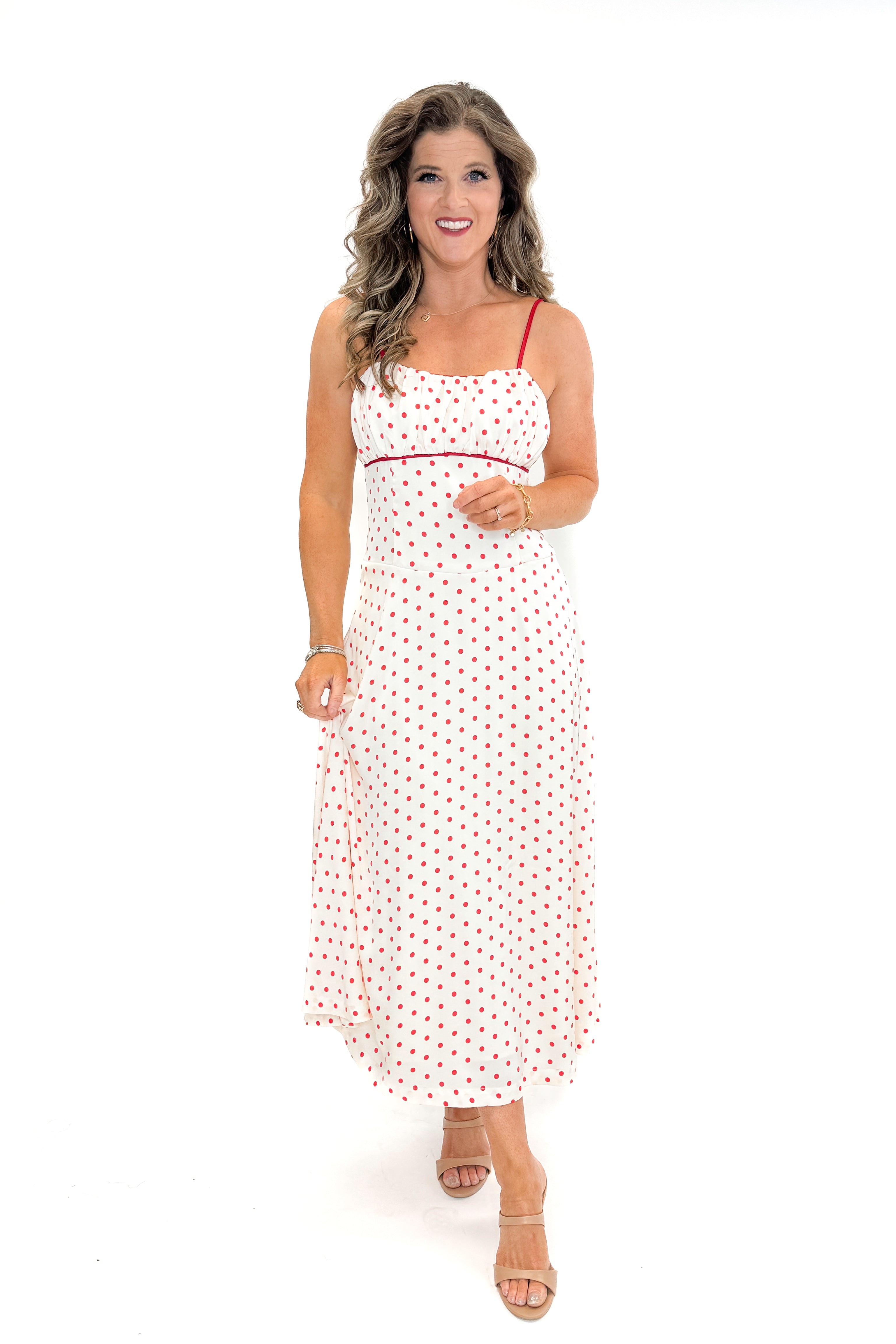 Front view of woman wearing Cream & Red Polka Dot Midi Dress by Skies Are Blue against white studio background.