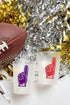 Two frosted glasses with foam finger designs next to a football and festive decorations.