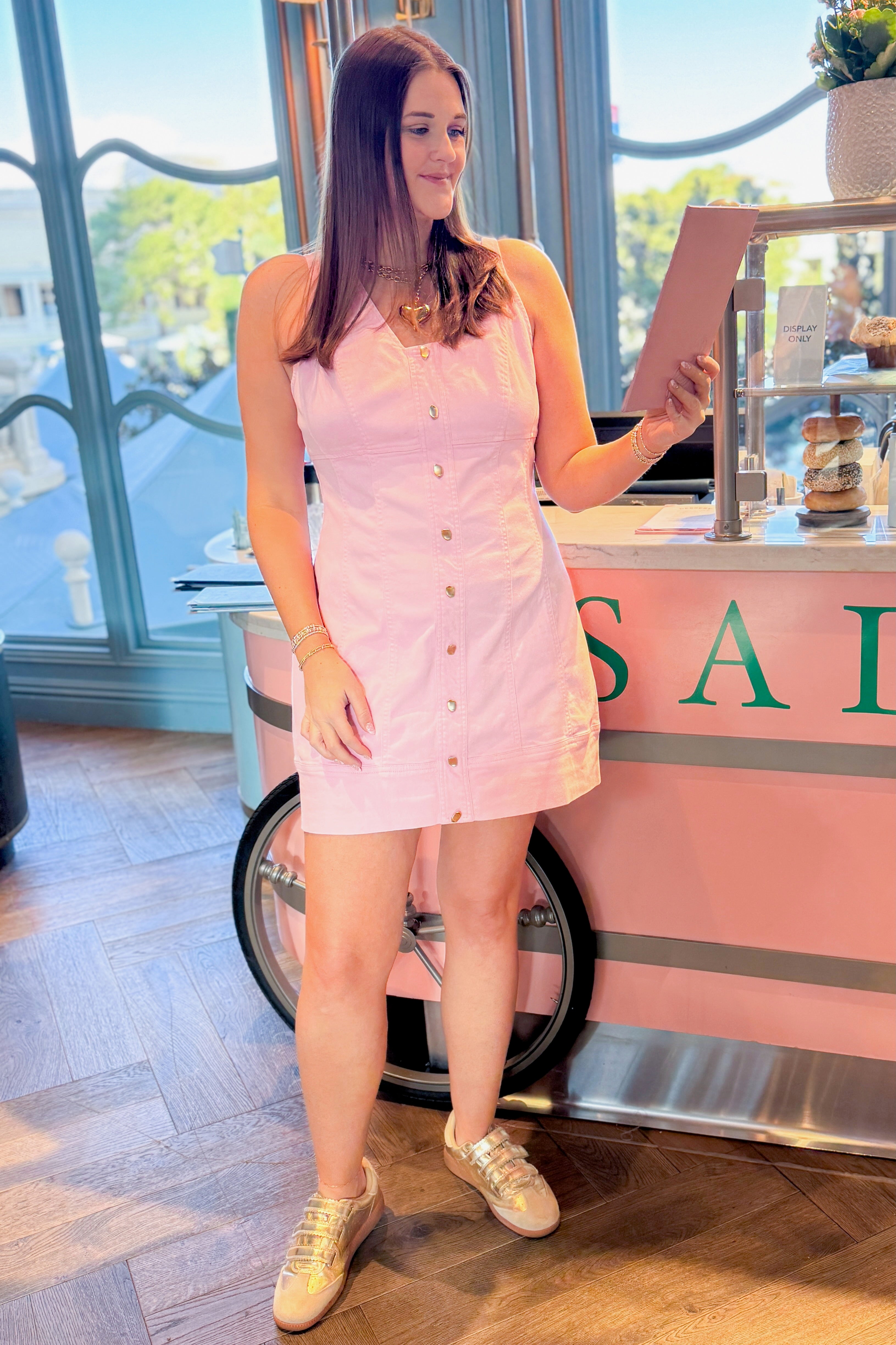 Front view of woman wearing Washed Pink Button Up Mini Dress by Skies Are Blue against at a restaurant.