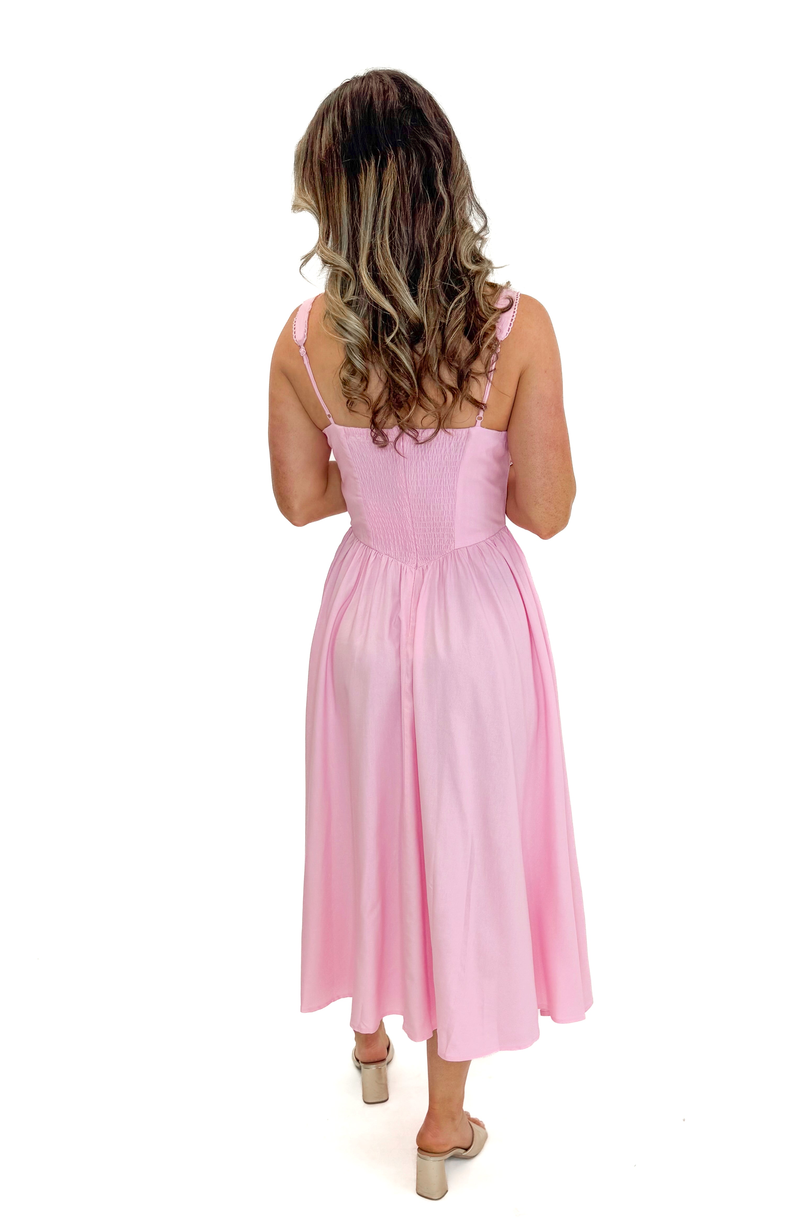 Back view of woman wearing Light Pink Drop Waist Midi Dress by Skies Are Blue against white studio background.
