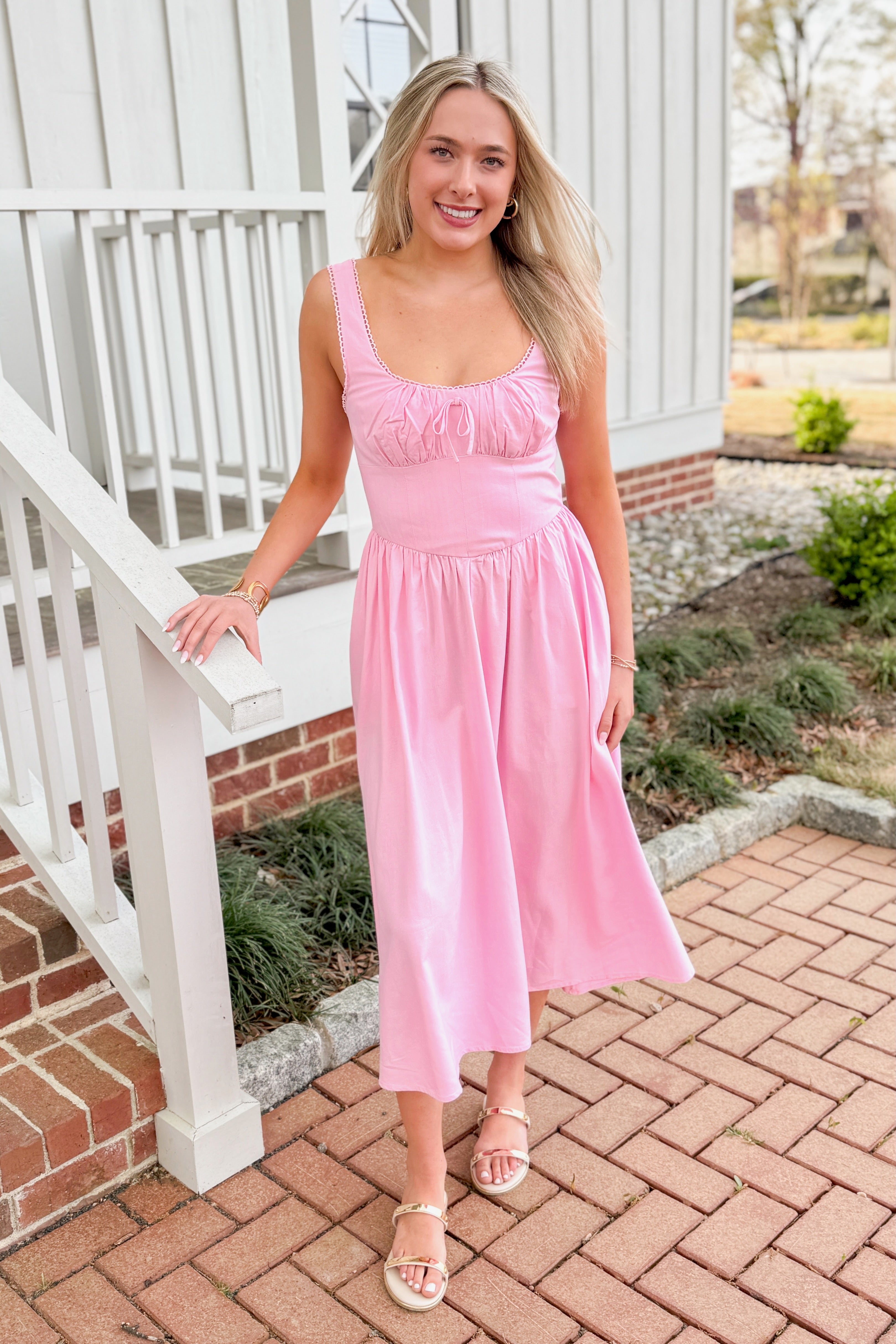 Front view of woman wearing Light Pink Drop Waist Midi Dress by Skies Are Blue outside.