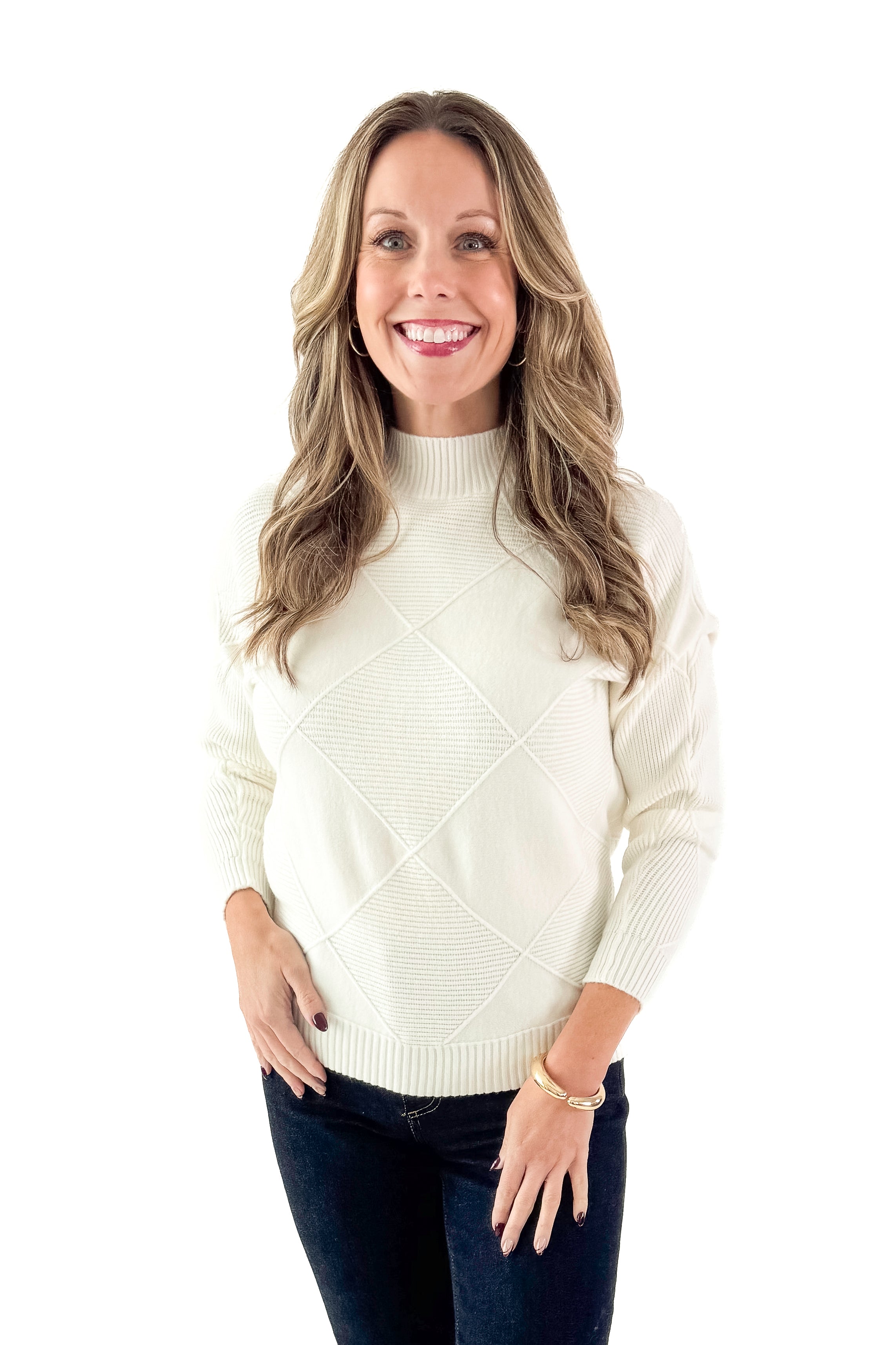 Front view of woman wearing Cream Diamond Mock Neck Sweater with jeans against white studio background