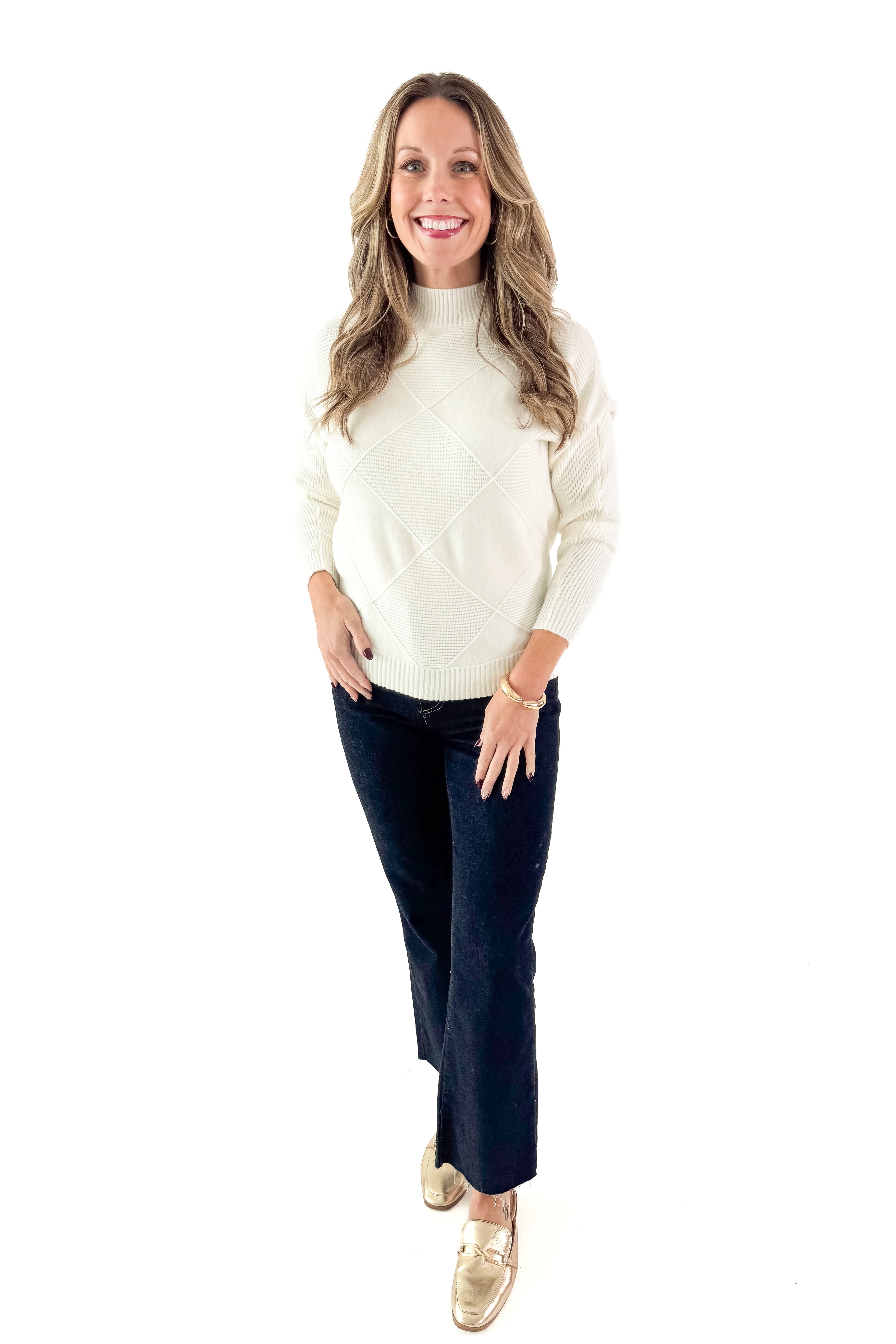 Front view of woman wearing Cream Diamond Mock Neck Sweater with jeans against white studio background