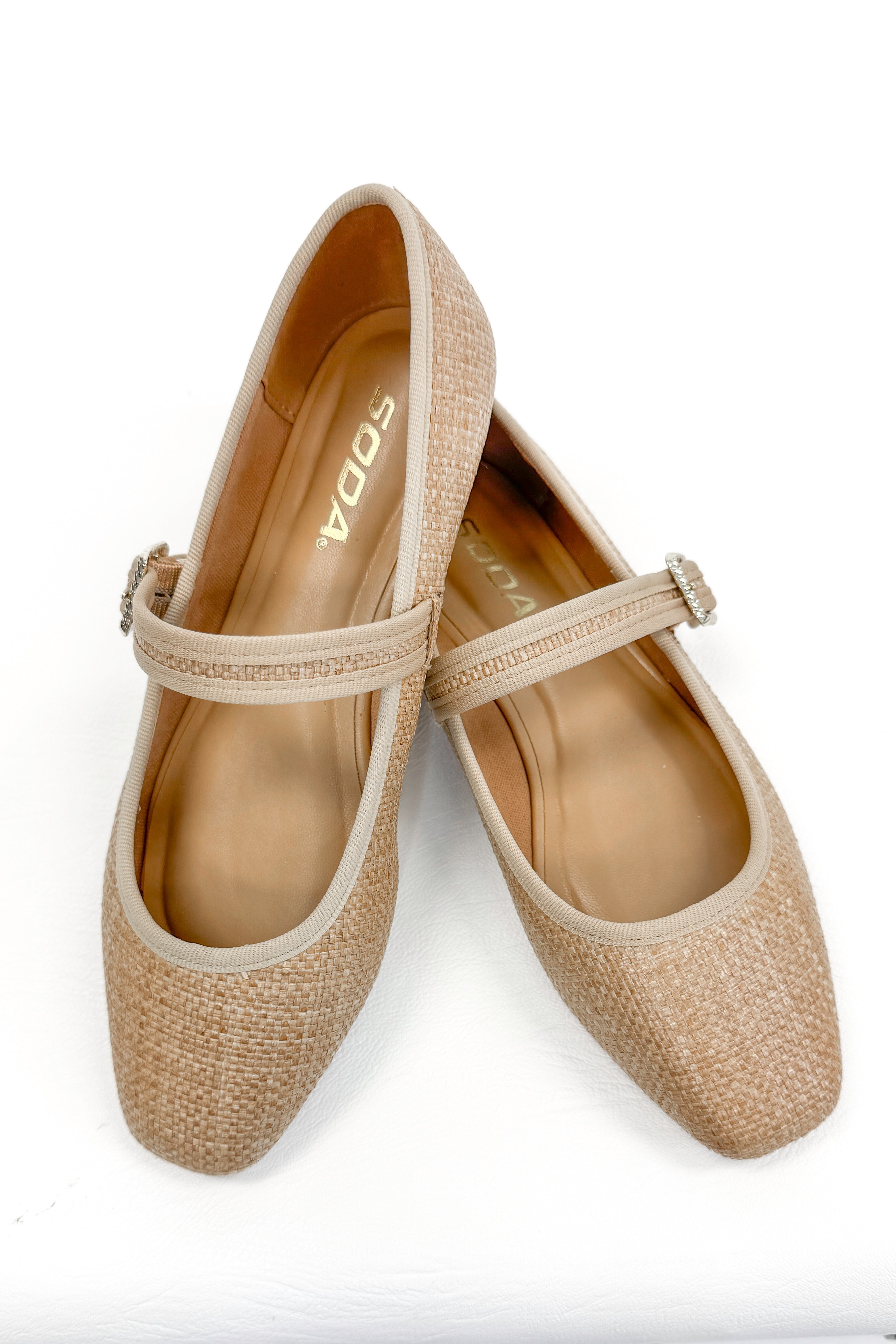 Adora- Natural Raffia Flats against white studio background.