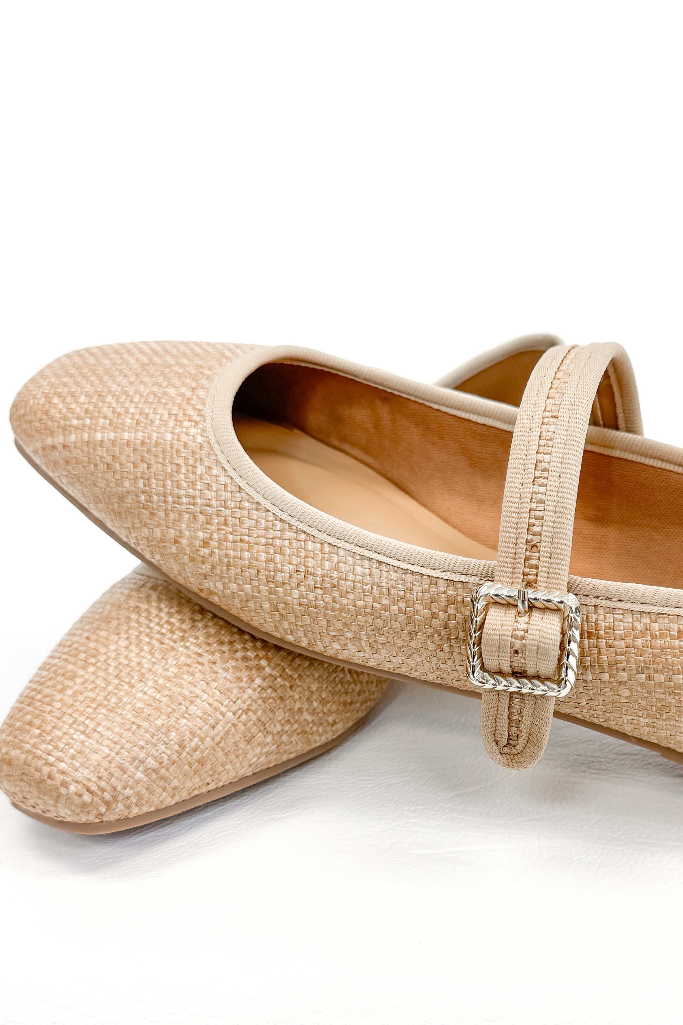 Adora- Natural Raffia Flats against white studio background close up.