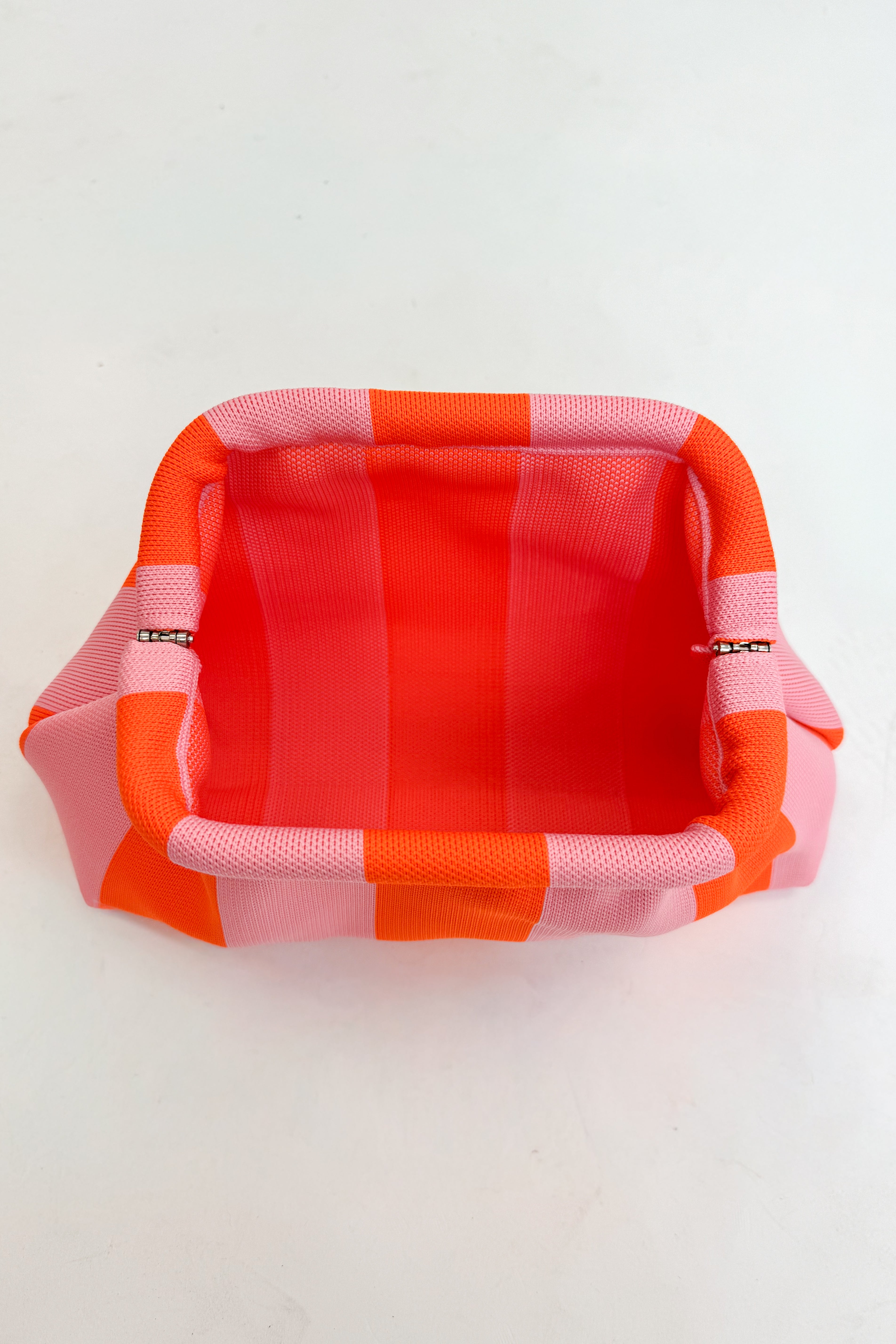 Rectangular fabric pouch with orange and pink striped pattern open on a white background