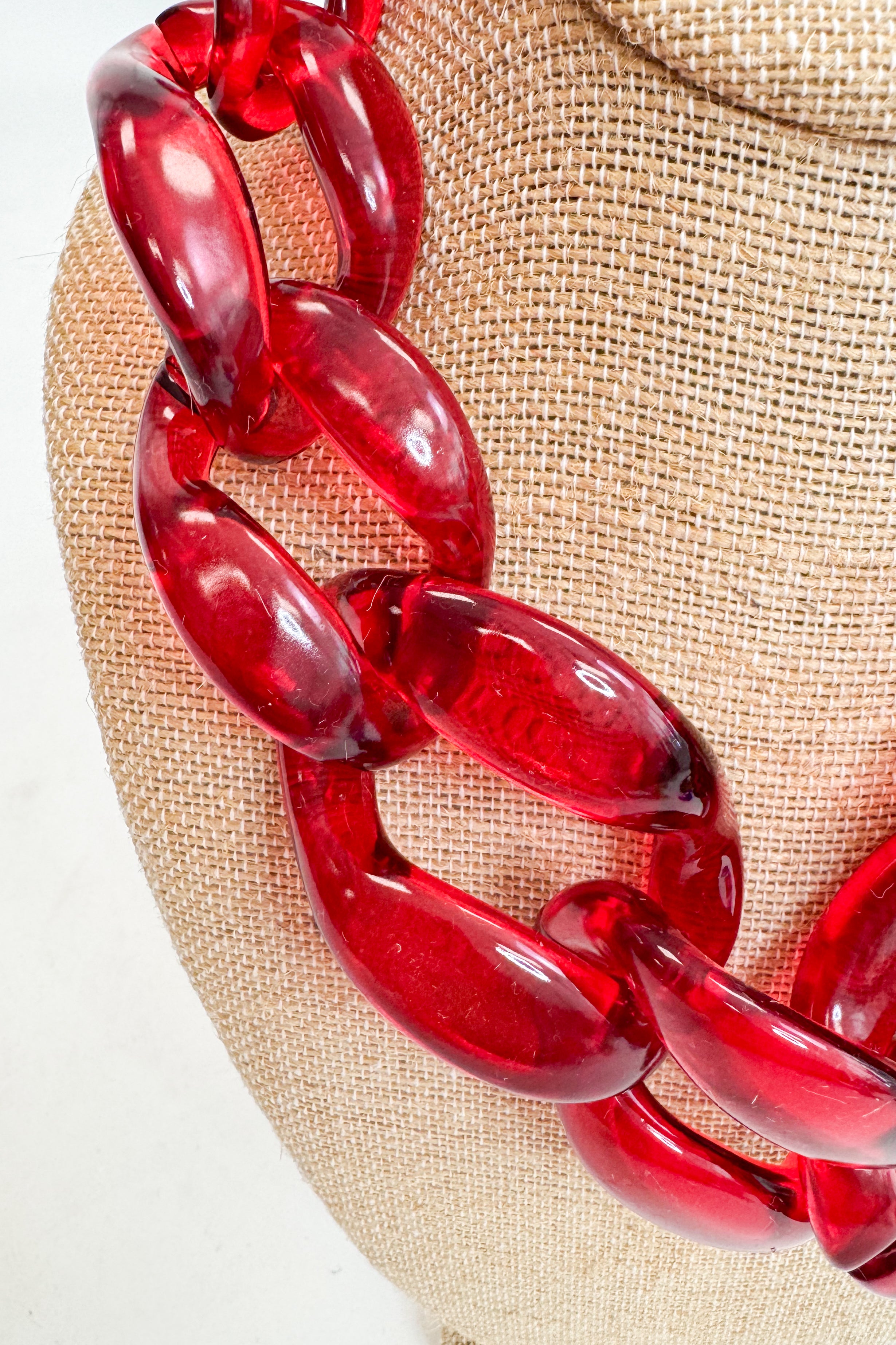 Red chain necklace on a beige fabric background