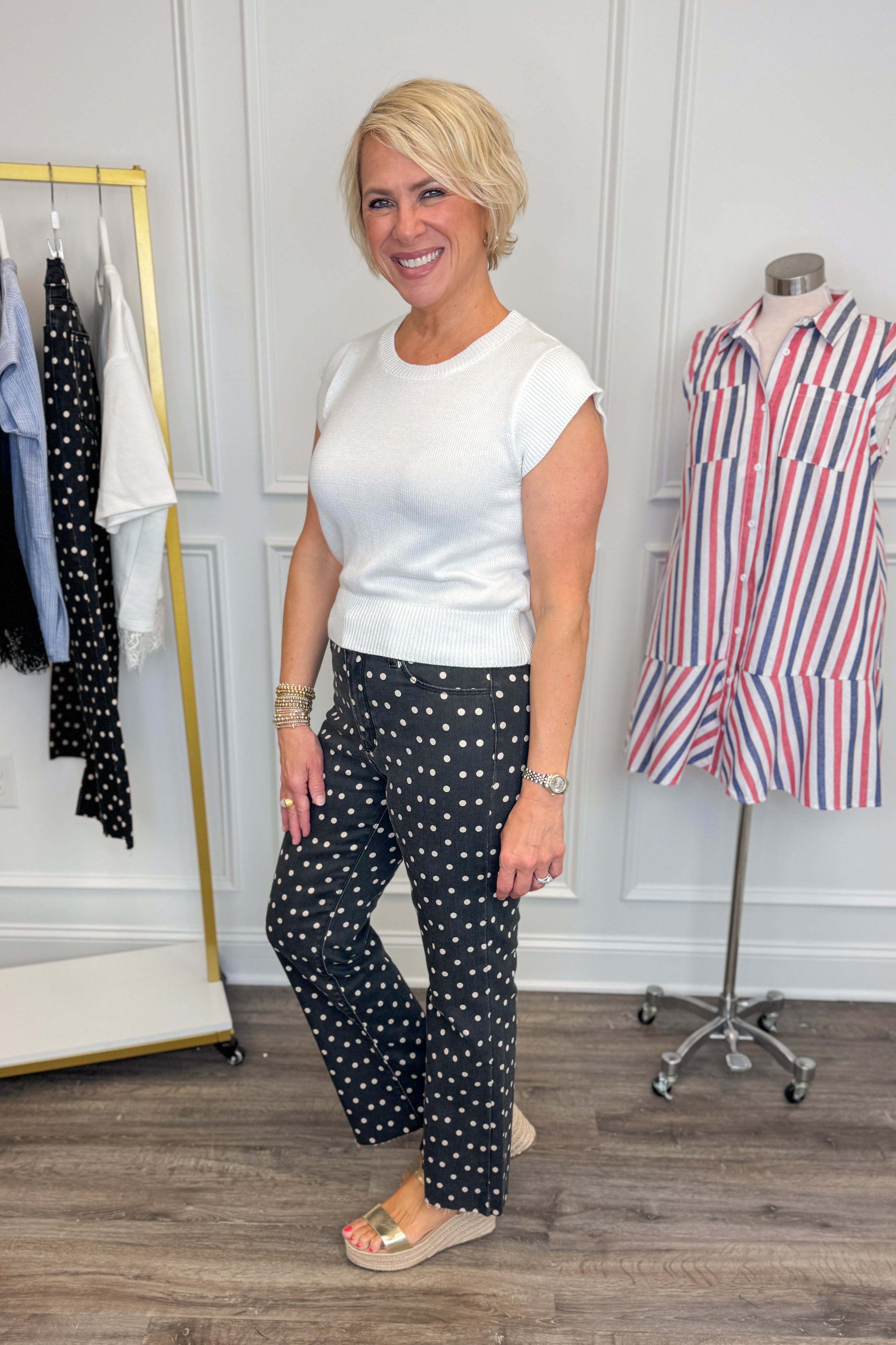 Side view of woman wearing Swagger Boutiqueās Black & White Polka Dot Crop Flare Jeans by Just Black Denim with top against white studio background.