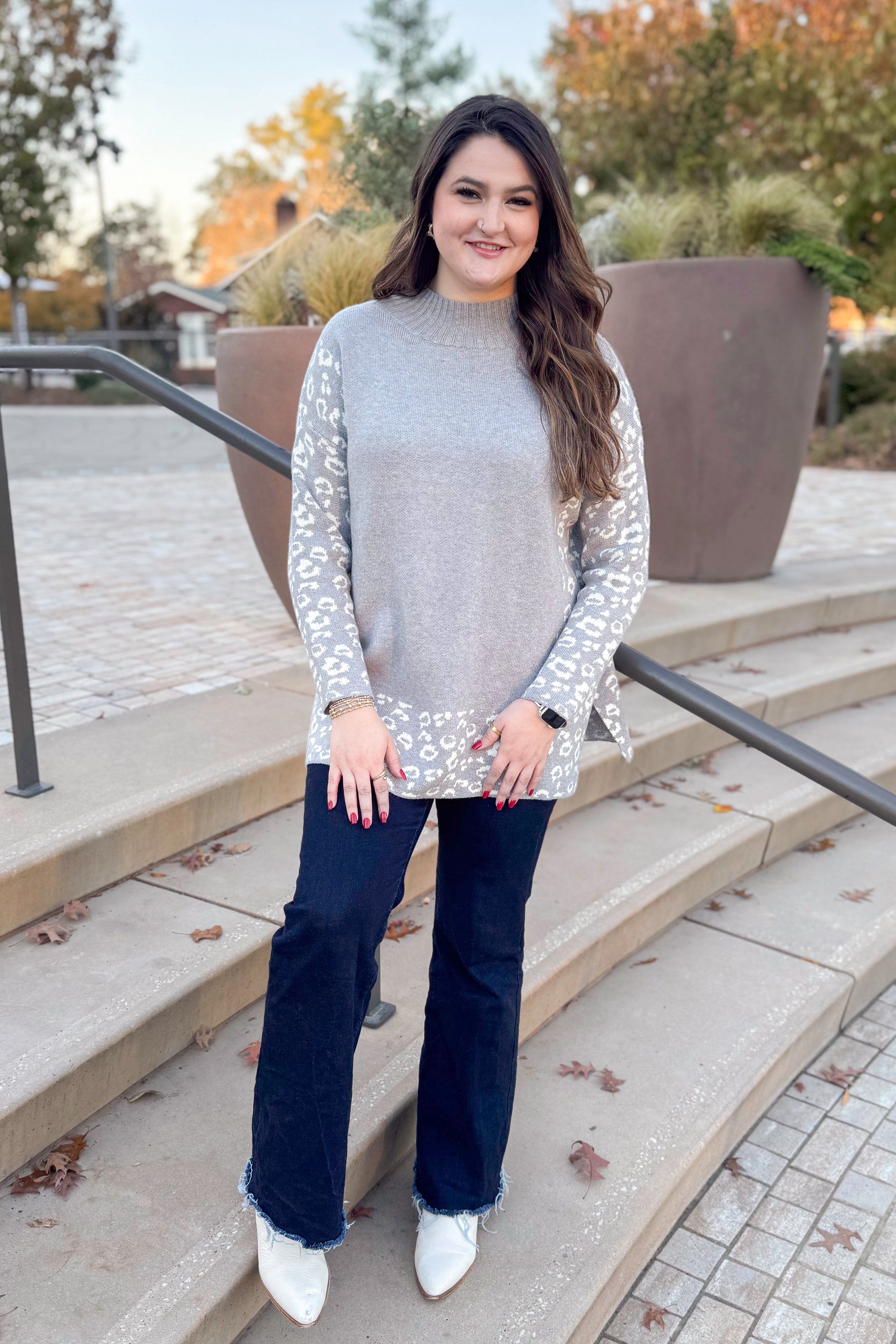 Front view of woman wearing Grey Leopard Print Lined Sweater with jeans outside.