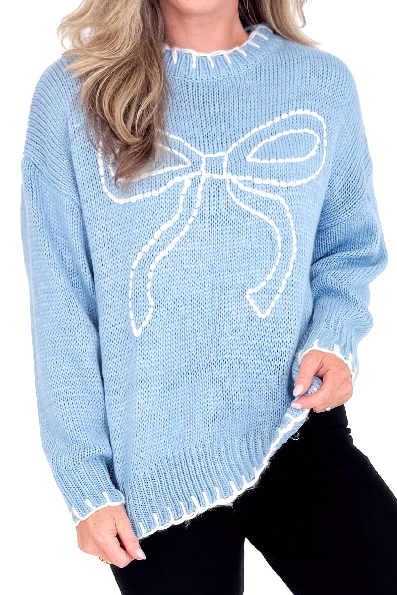Light blue sweater with a large bow design worn by a person.
