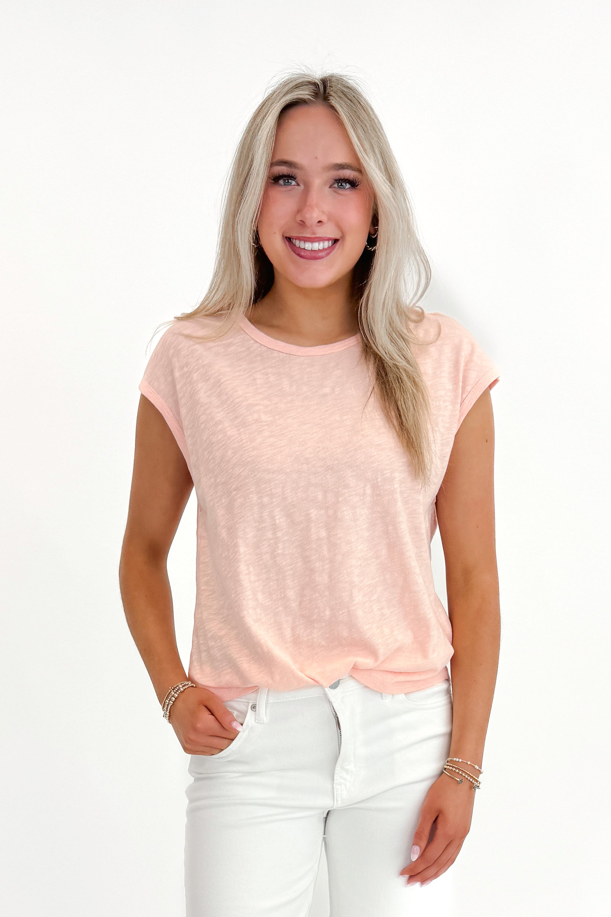 Front view of woman wearing Bellini Sol Slub Tank by Z Supply with jeans against white studio background.