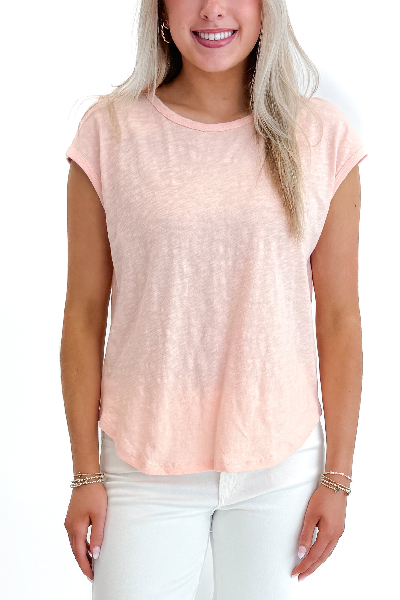 Front detail view of woman wearing Bellini Sol Slub Tank by Z Supply with jeans against white studio background.