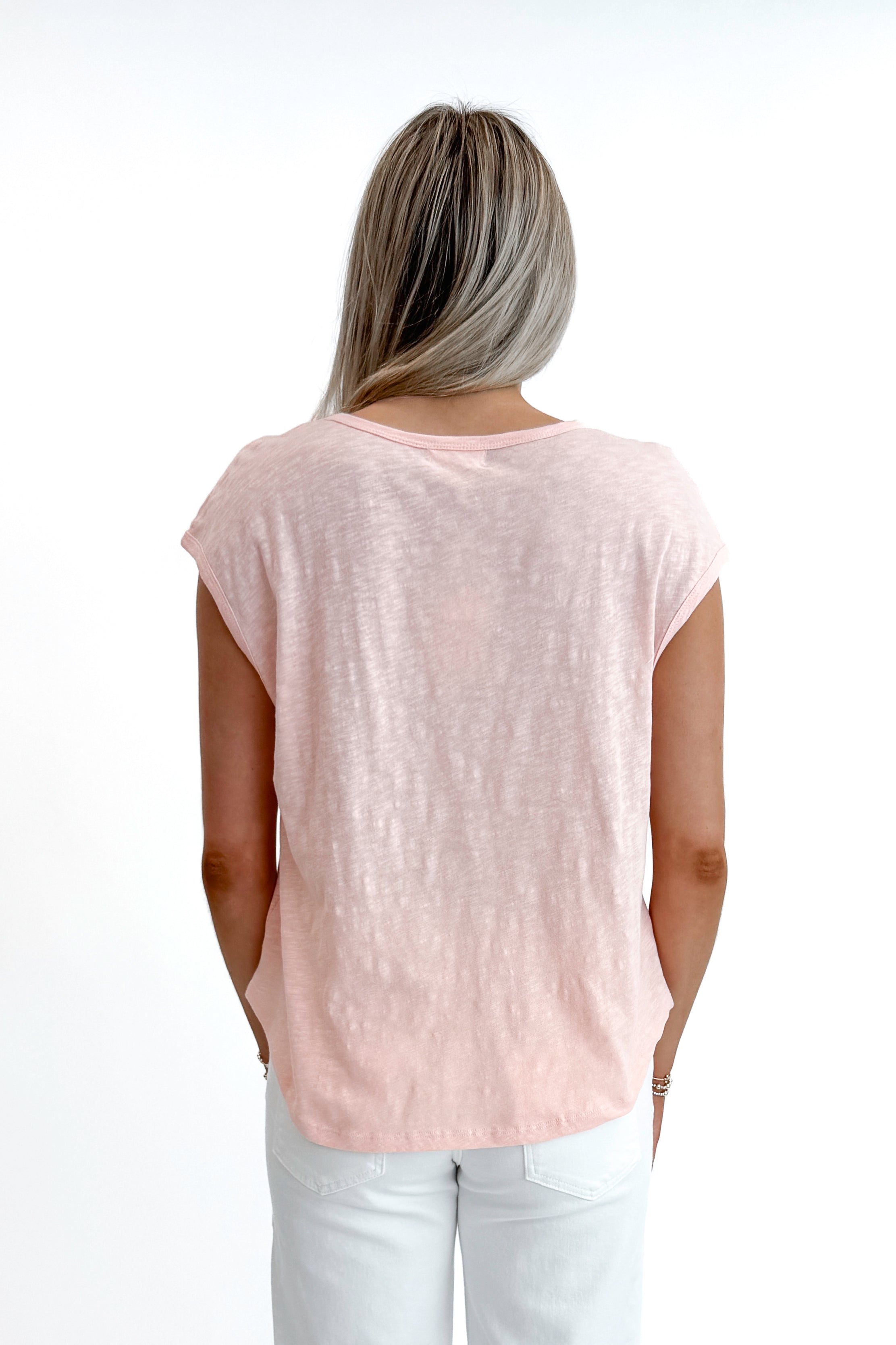 Back view of woman wearing Bellini Sol Slub Tank by Z Supply with jeans against white studio background.