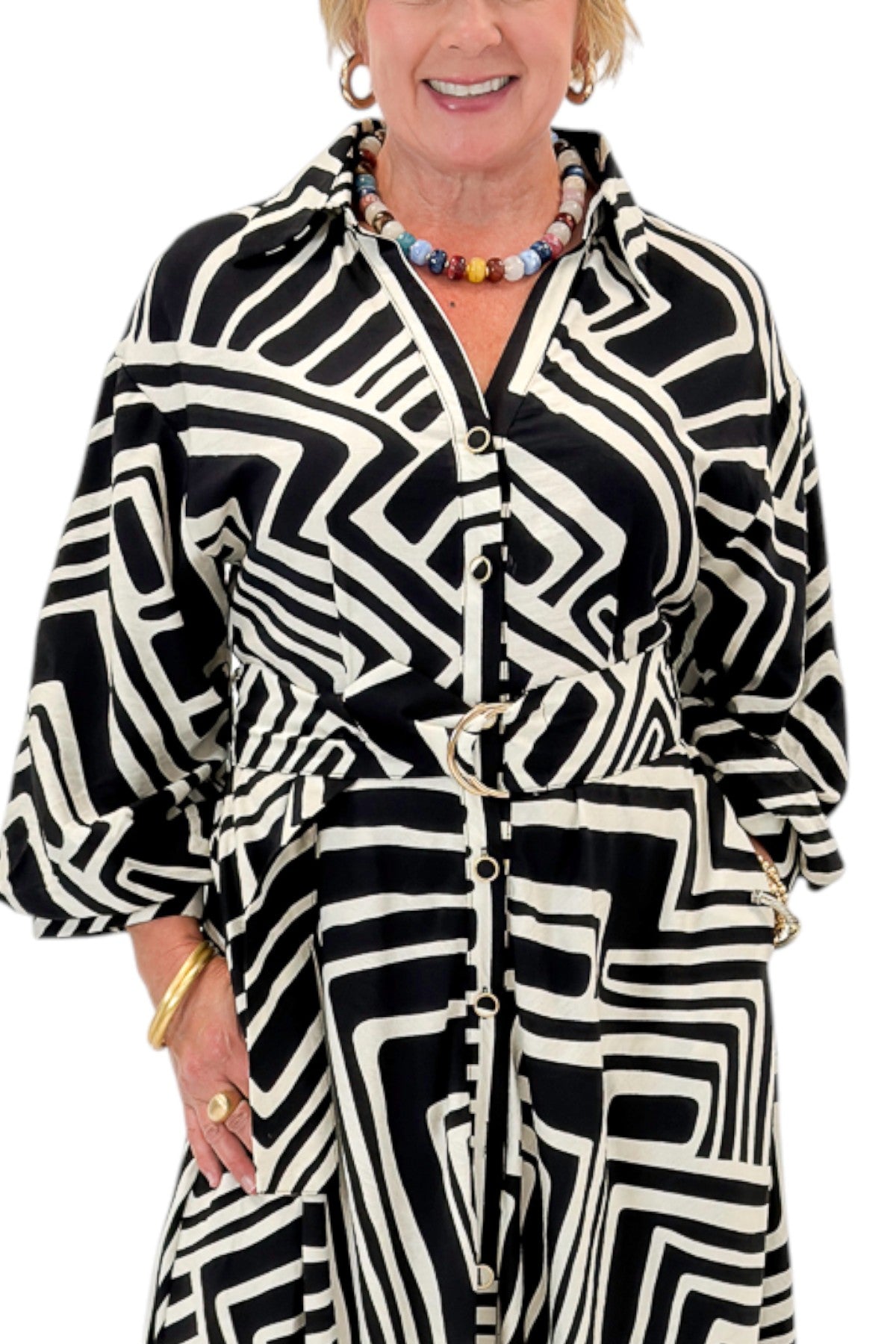 Front detail view of woman wearing Swagger Boutiqueās Black Abstract Print Midi Dress by Entro with heels against white studio background.