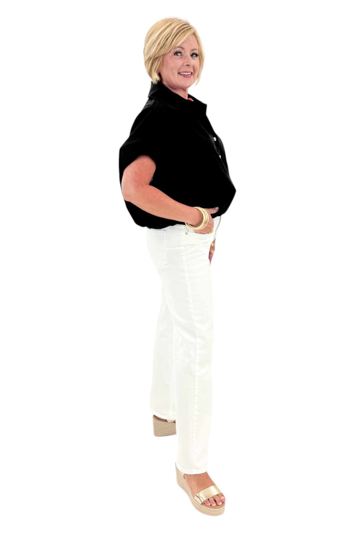 Side view of woman wearing Swagger Boutique’s Black Collared Bubble Hem Top with jeans against white studio background.