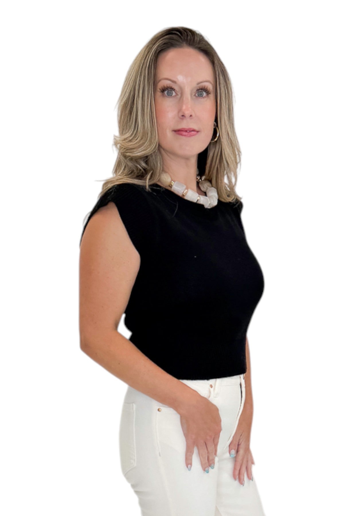 Side view of woman wearing Swagger Boutique’s Black Cap Sleeve Sweater with jeans against white studio background.