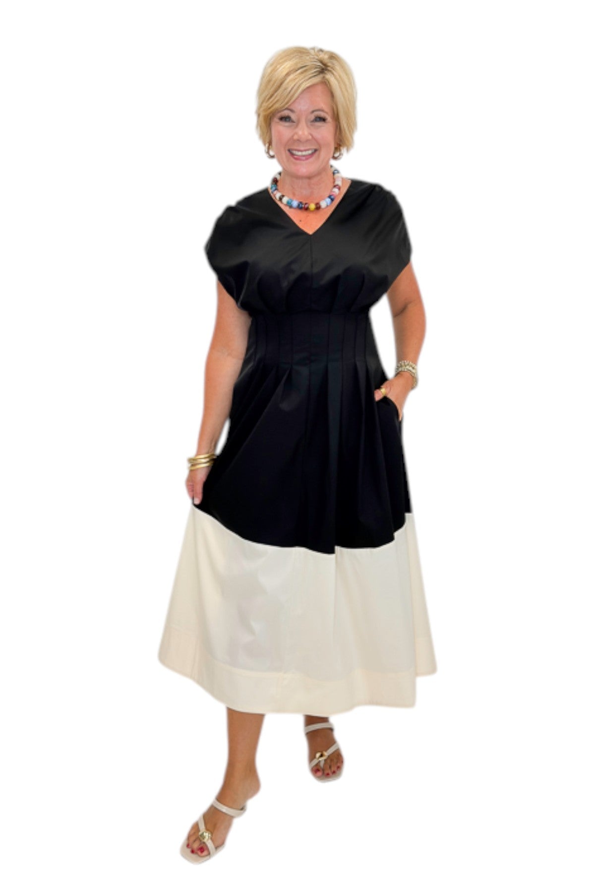 Front view of woman wearing Swagger Boutiqueās Black & Cream Color Block Midi Dress by Entro with sandals against white studio background.