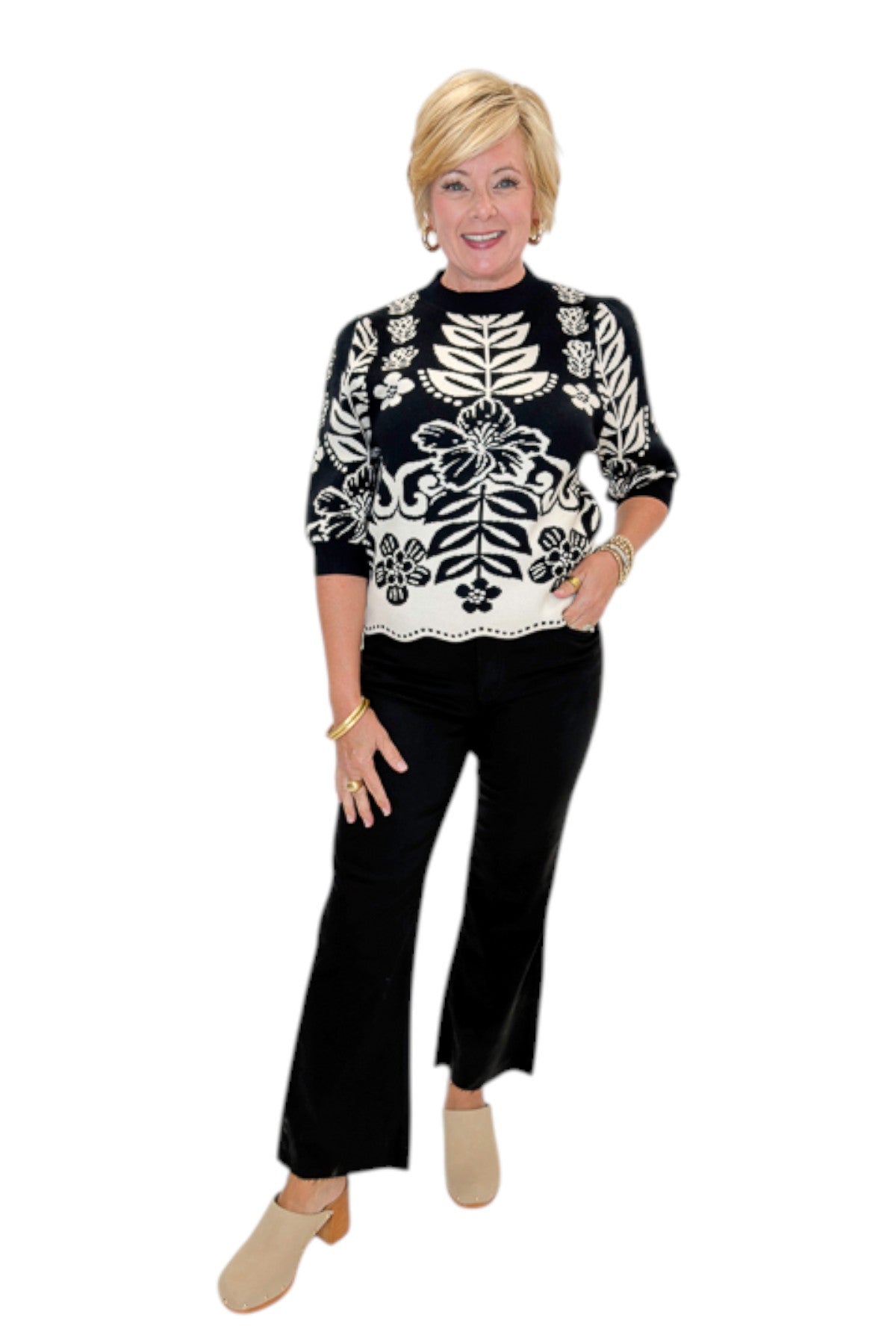 Front view of woman wearing Swagger Boutiqueās Black & Cream Printed Short Sleeve Sweater by THML with jeans against white studio background.