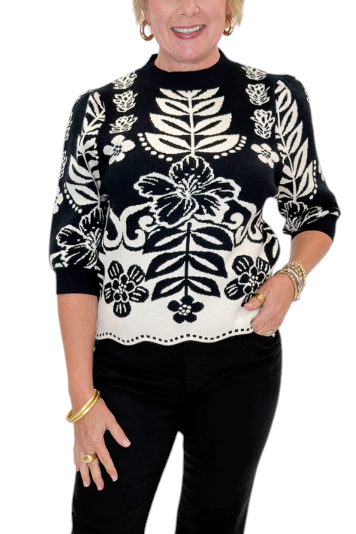 Front detail view of woman wearing Swagger Boutiqueās Black & Cream Printed Short Sleeve Sweater by THML with jeans against white studio background.