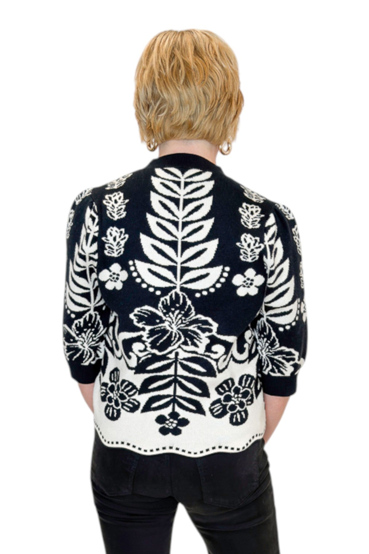 Back view of woman wearing Swagger Boutiqueās Black & Cream Printed Short Sleeve Sweater by THML with jeans against white studio background.